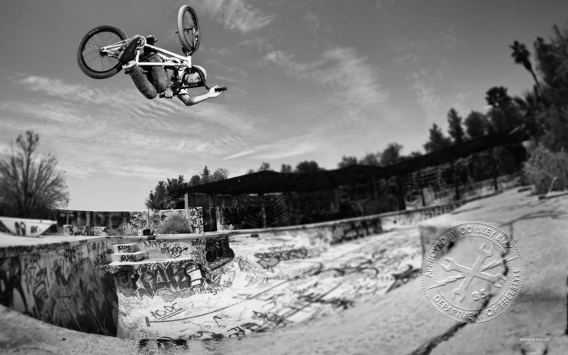 A Bmx Rider Flying Off A Half-pipe Ramp Background