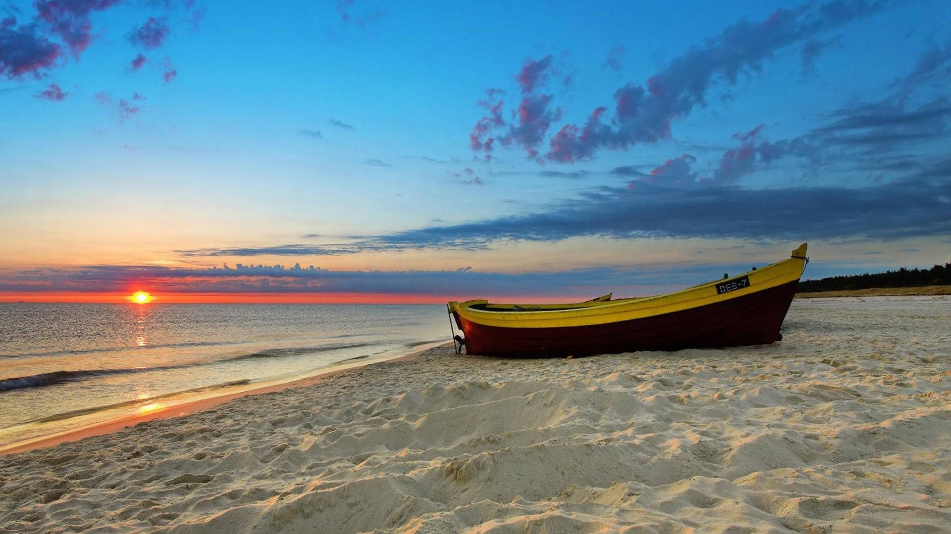 A Boat On The Beach At Sunset Background