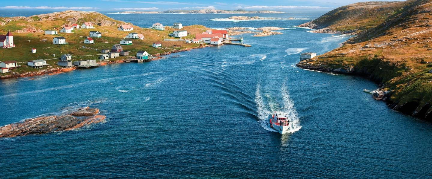 A Boat Passing Through Newfoundland's Coast Background