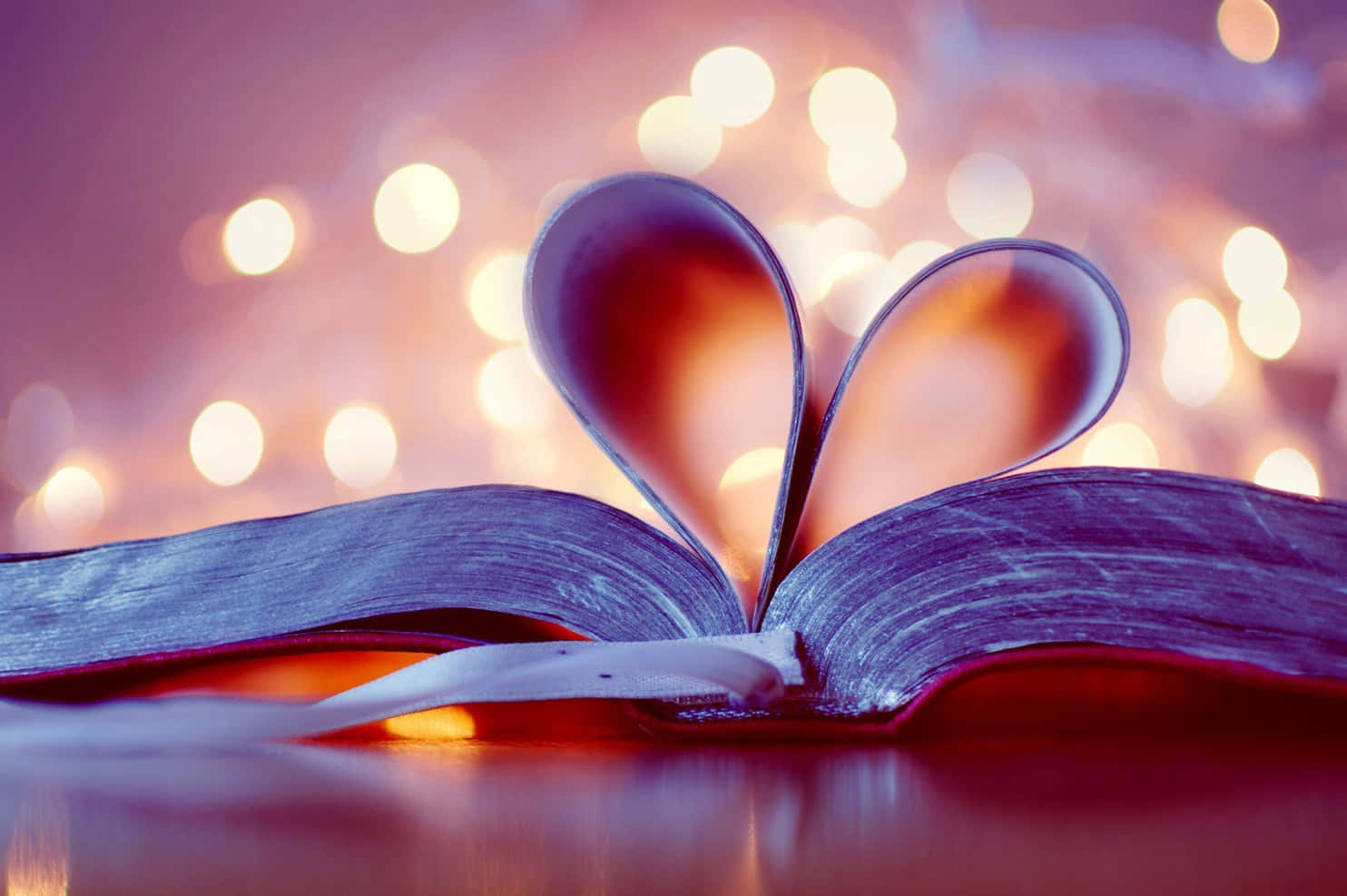 A Book With A Heart Cut Out Of It On Top Of A Table Background