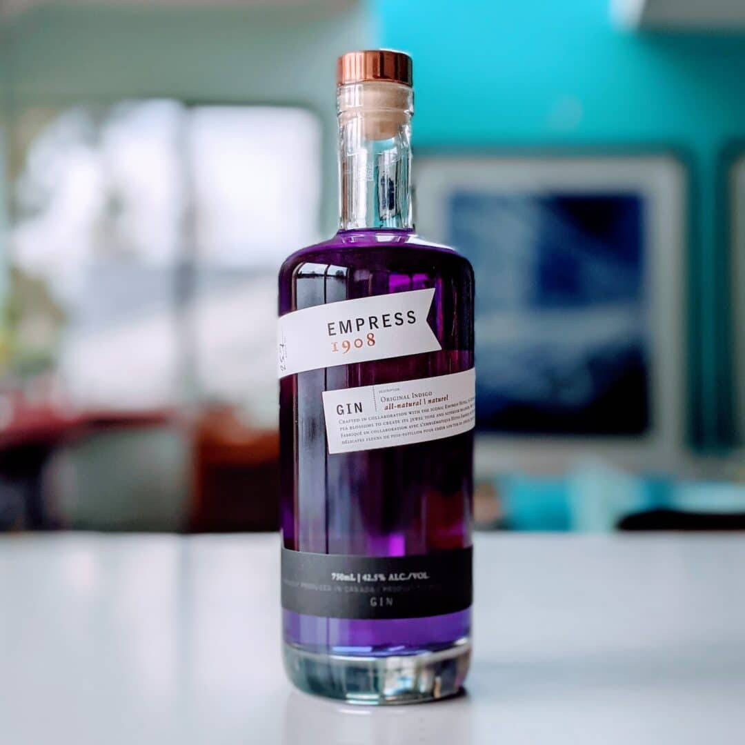 A Bottle Of Empress 1908 Gin Presented On A Sleek, Modern Table. Background