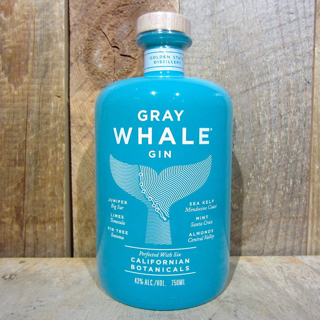 A Bottle Of Gray Whale Gin Set Against A Wooden Backdrop