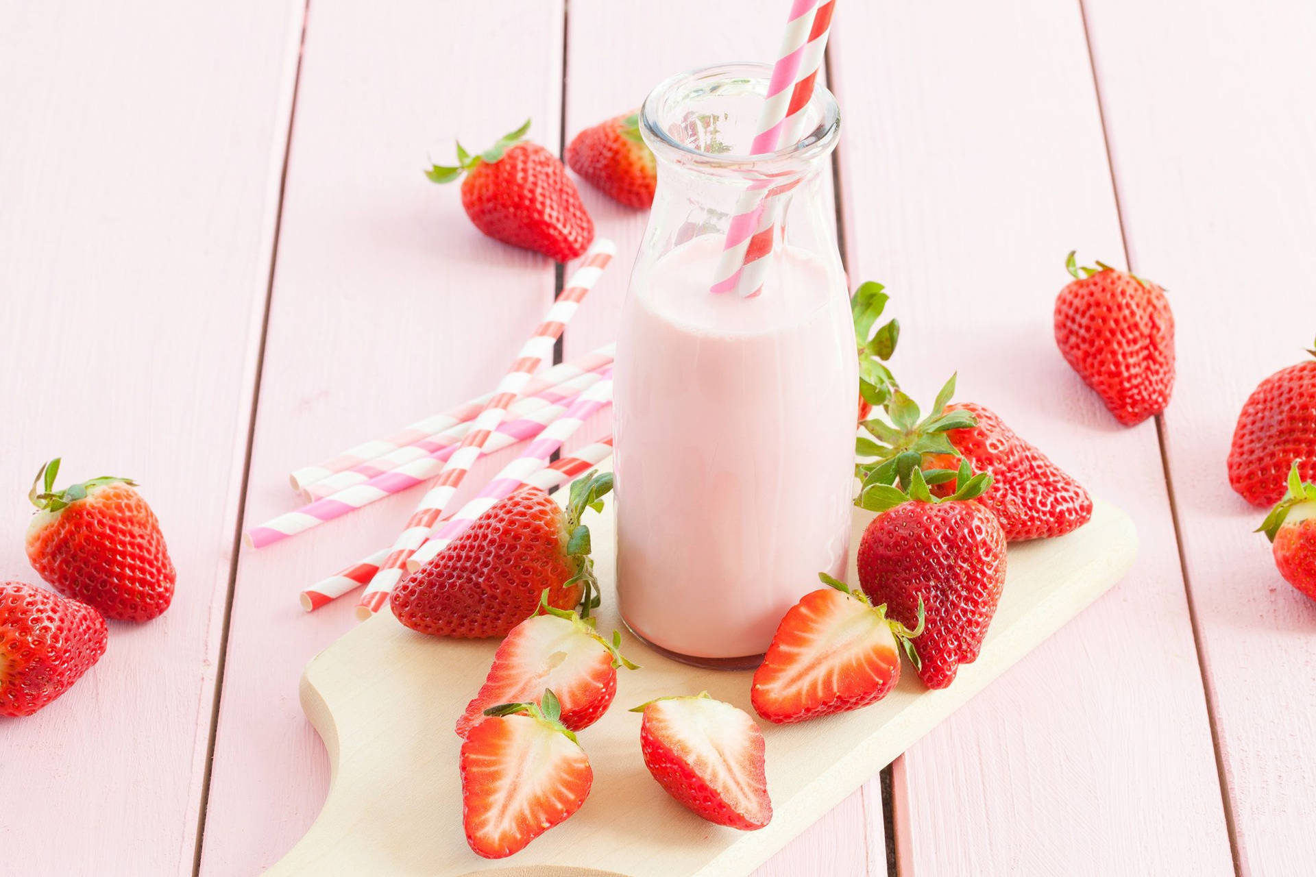 A Bottle Of Milk With Strawberries On A Pink Wooden Table