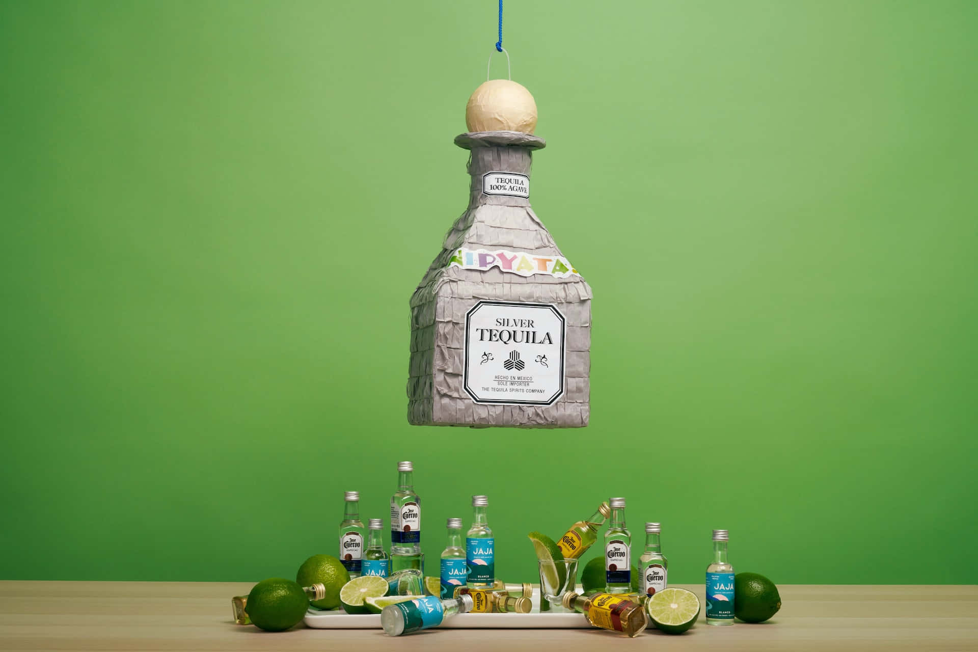 A Bottle Of Tequila Hanging From A Green Table Background