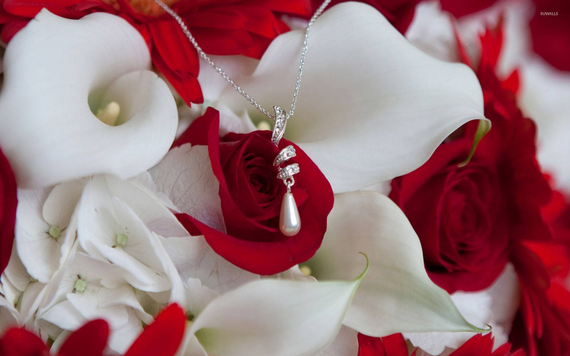 A Bouquet Of Red And White Flowers With A Necklace Background