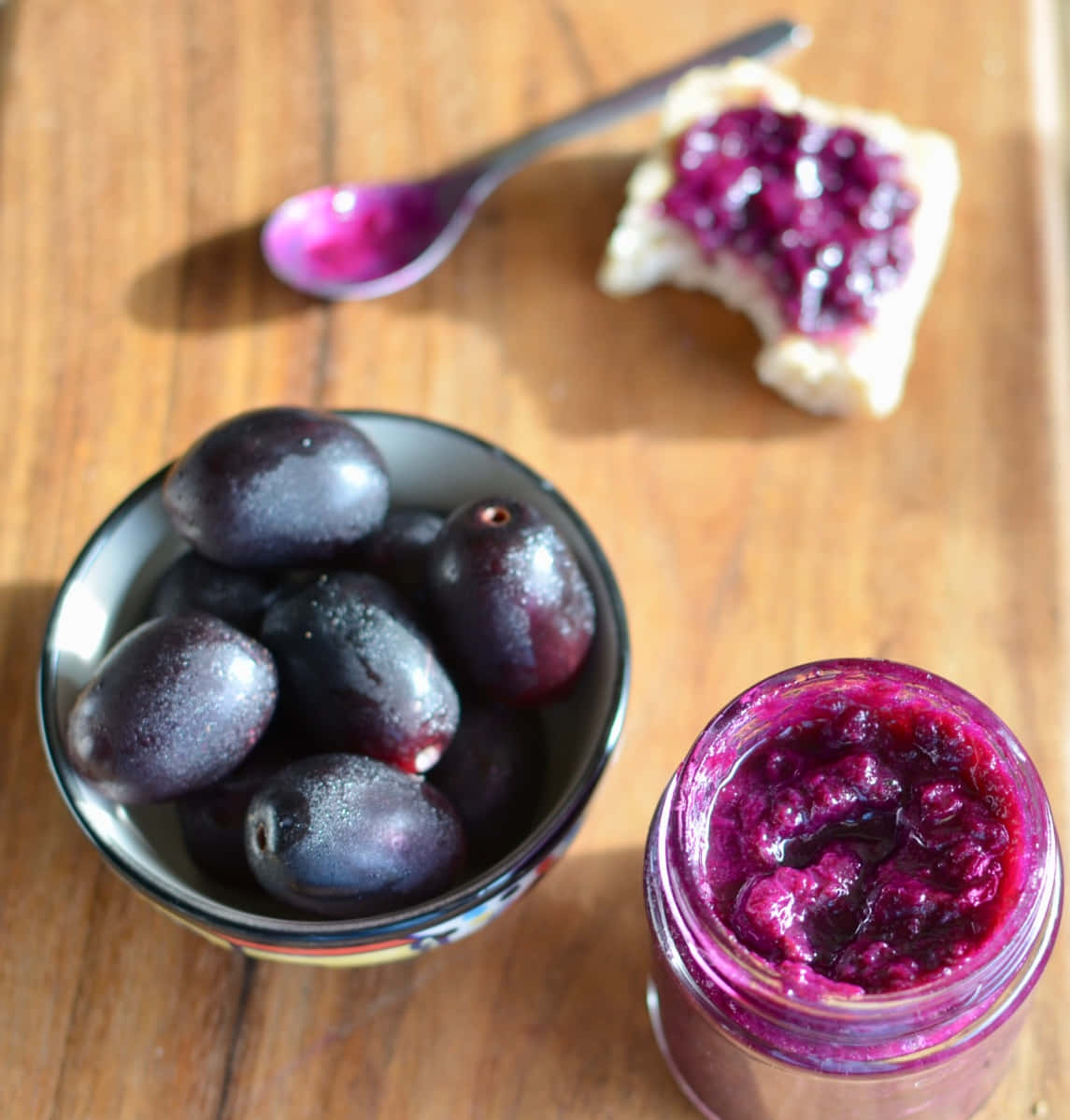 A Bowl Full Of Fresh Java Plums Beside A Jar Of Homemade Jam Background