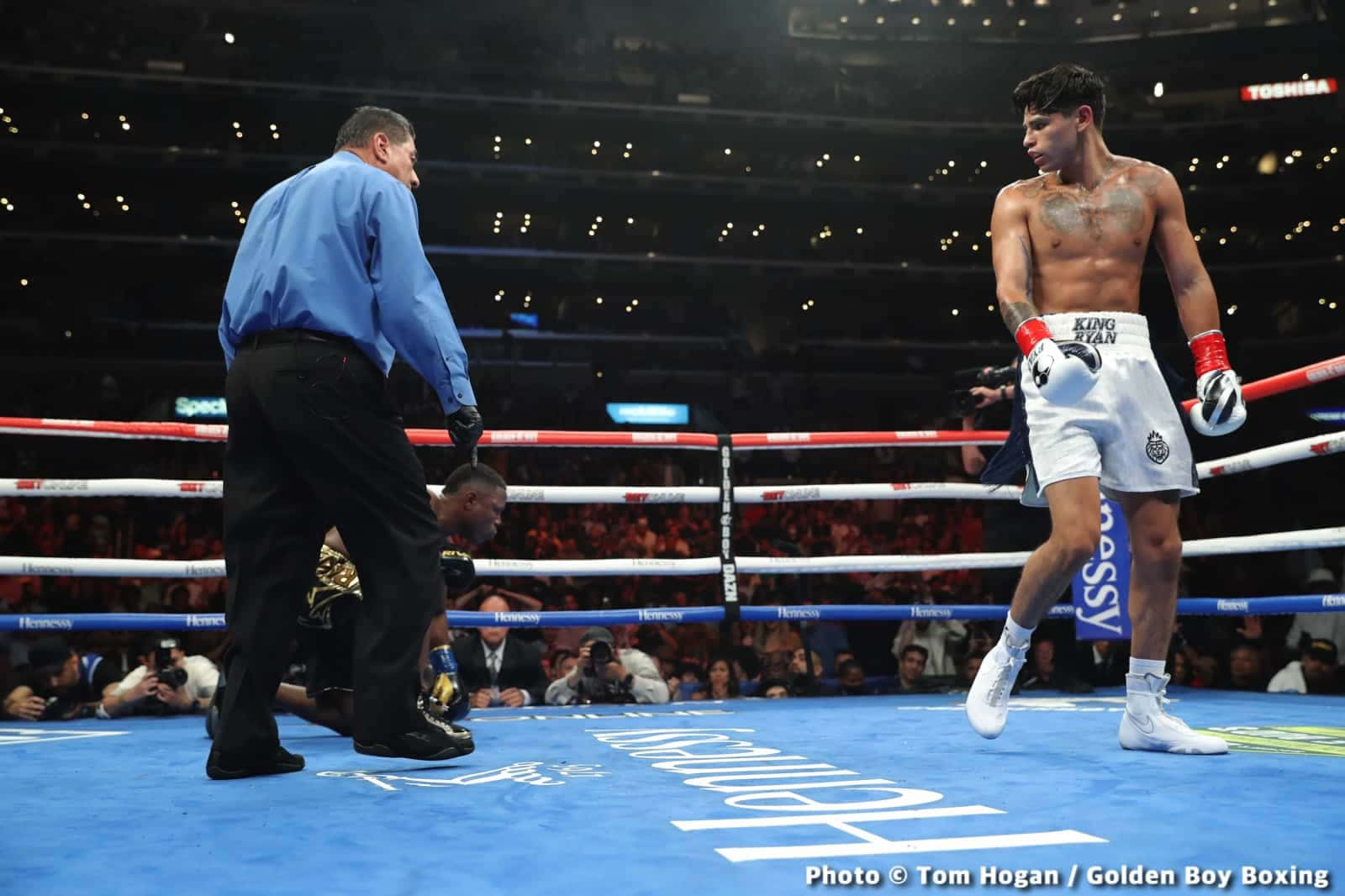 A Boxer Is Standing On The Ring With A Referee Background