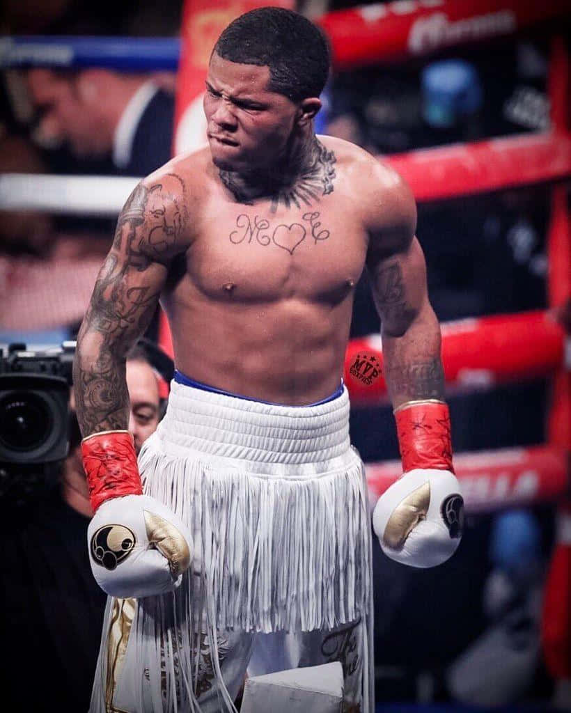 A Boxer With Tattoos Standing In The Ring Background