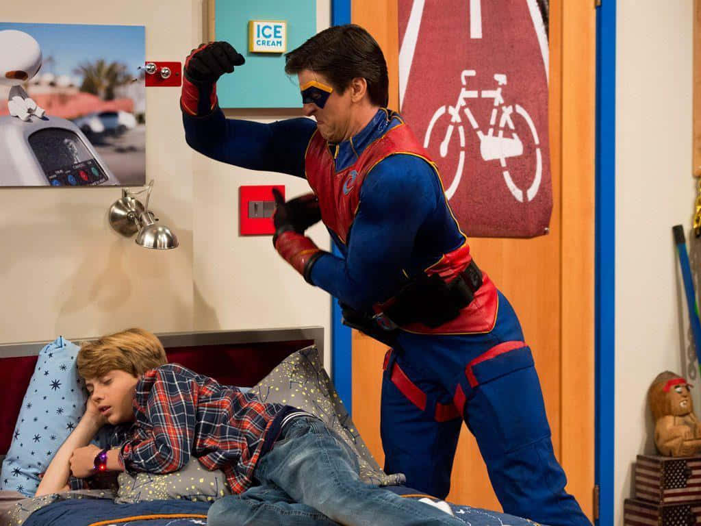 A Boy In A Superhero Costume Is Fighting With Another Boy In A Bedroom Background