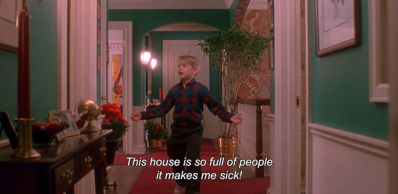 A Boy Is Standing In A Hallway With A Sign Saying This House Is So Full Of People Background