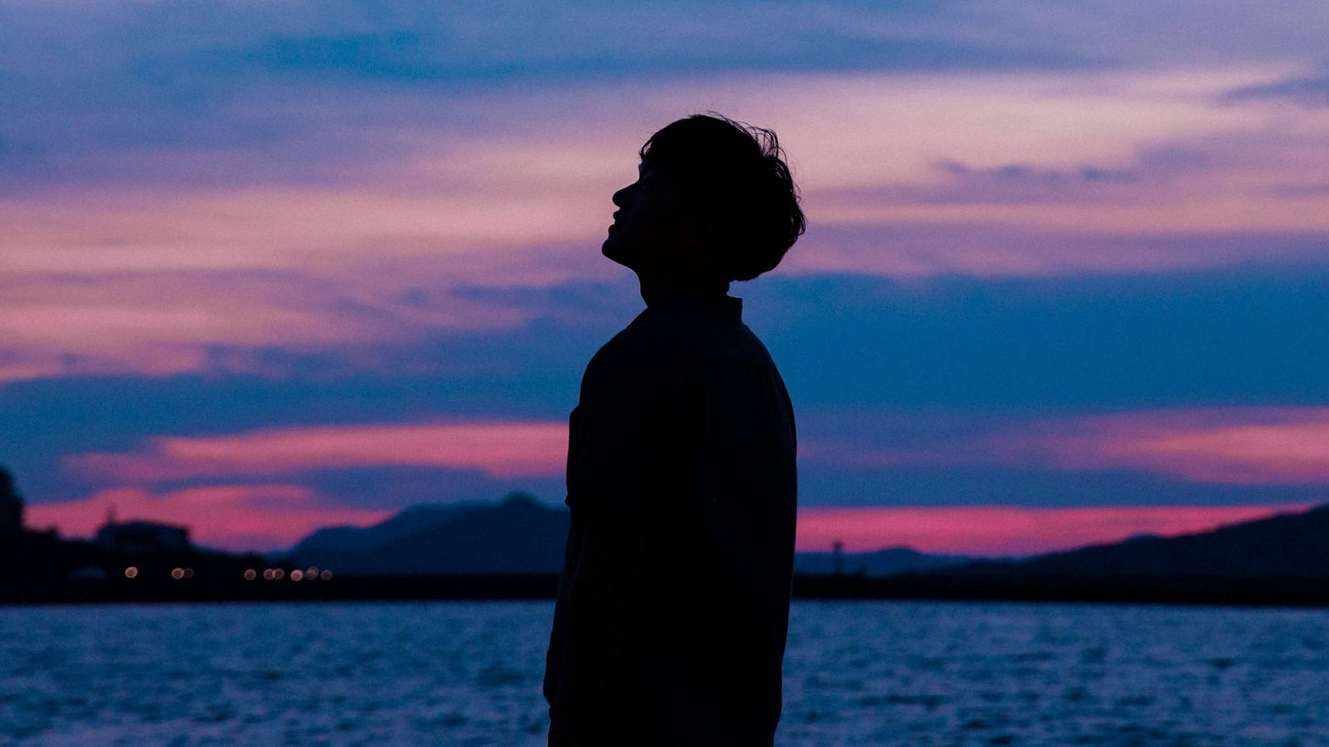 A Boy Stands Tall Against A Beautiful Purple Sky Background