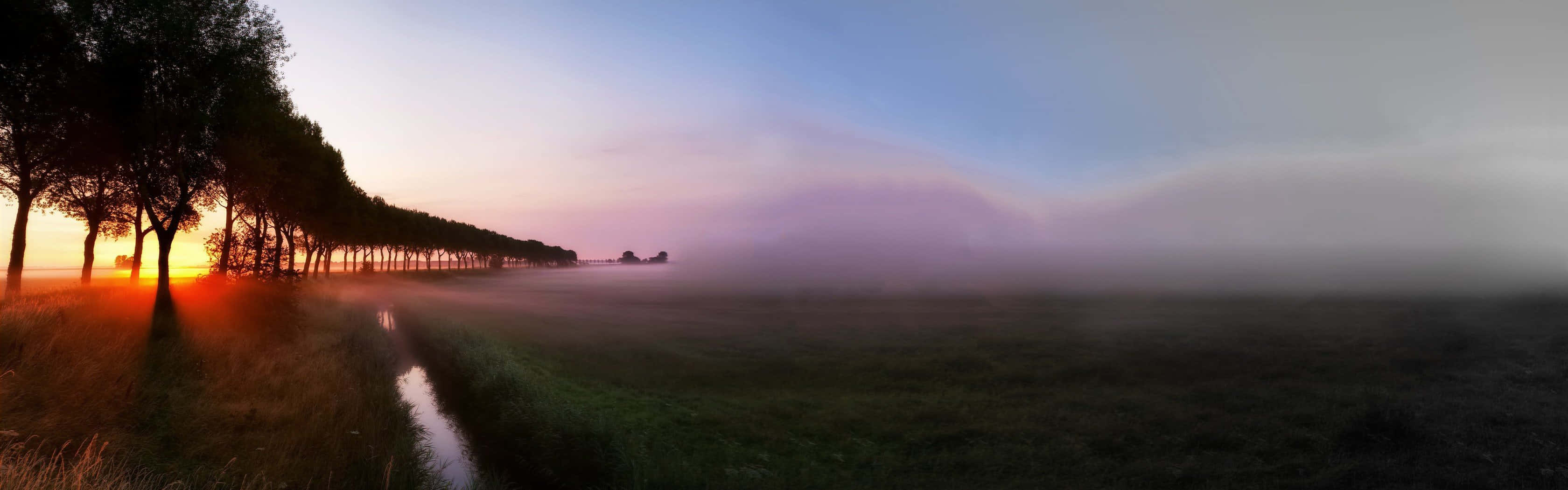 A Breathtaking View Of The Town On A Foggy Morning Background