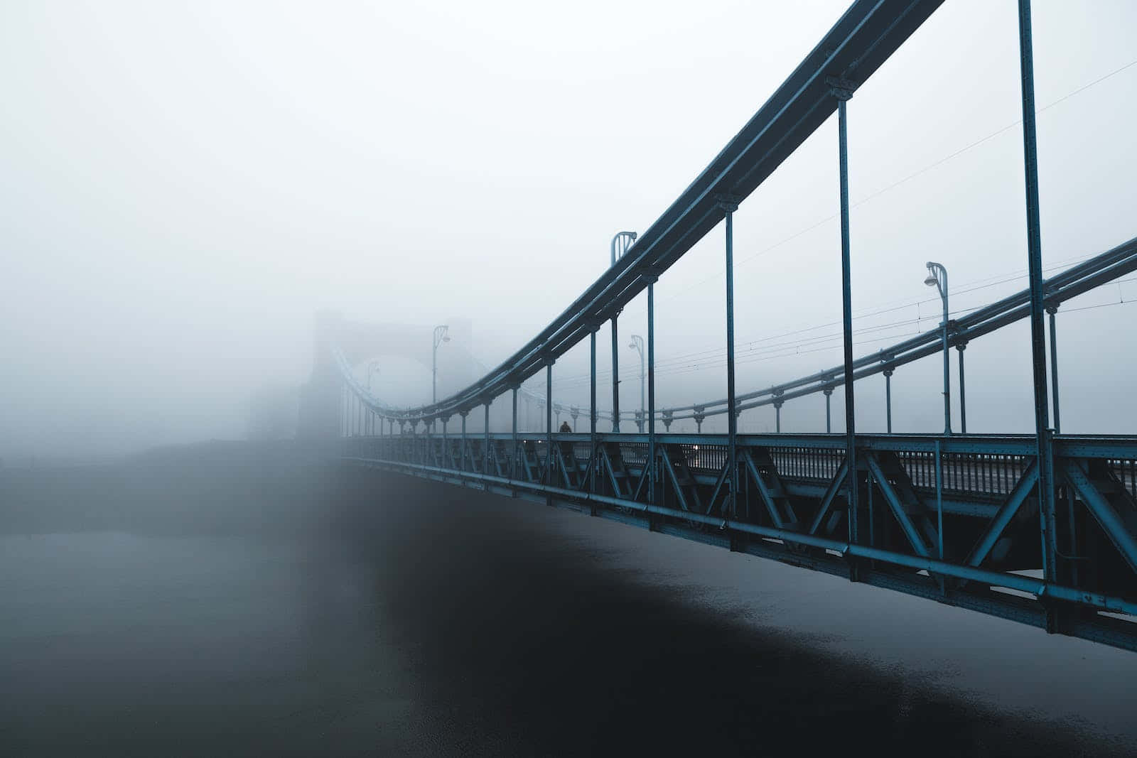 A Bridge In The Fog With A Blue Railing Background