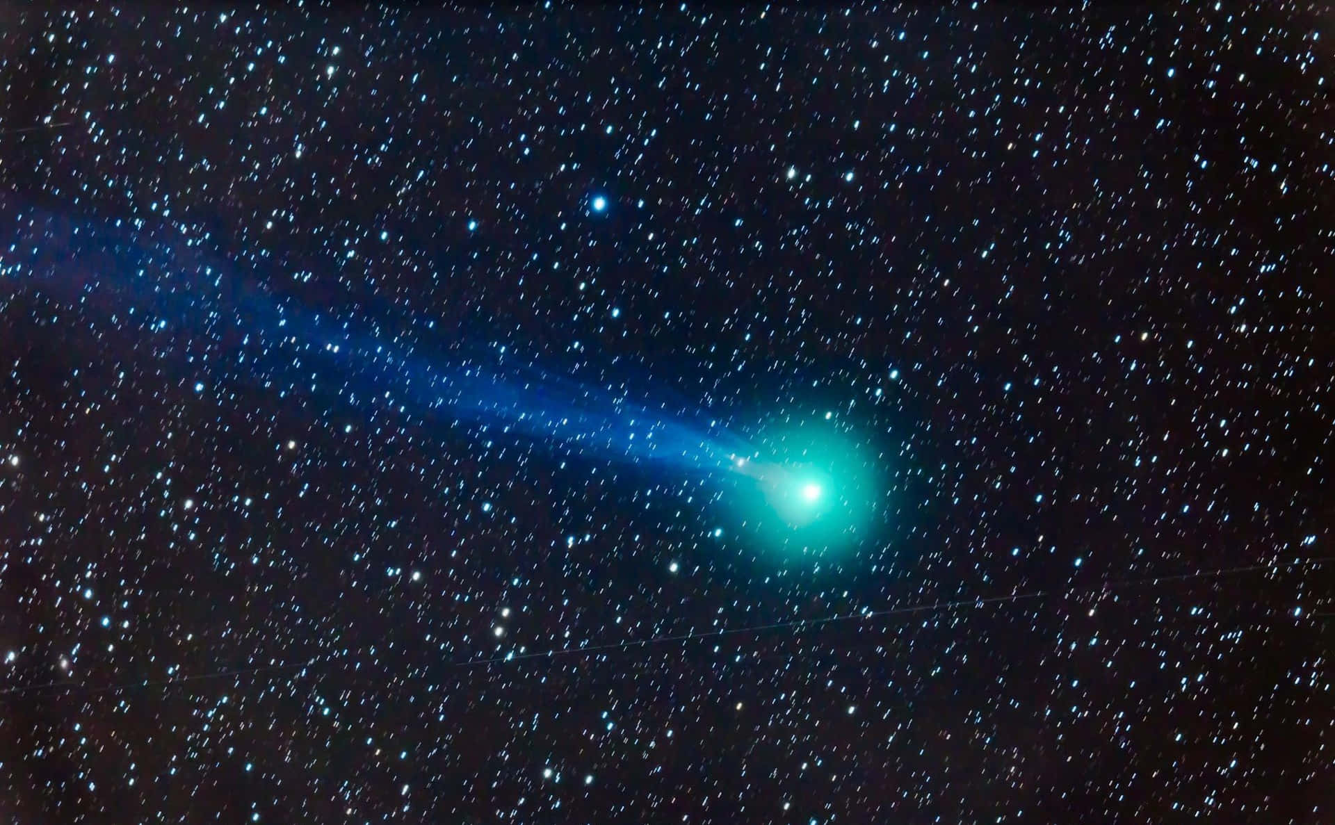 A Bright Comet Streaking Across The Night Sky Background