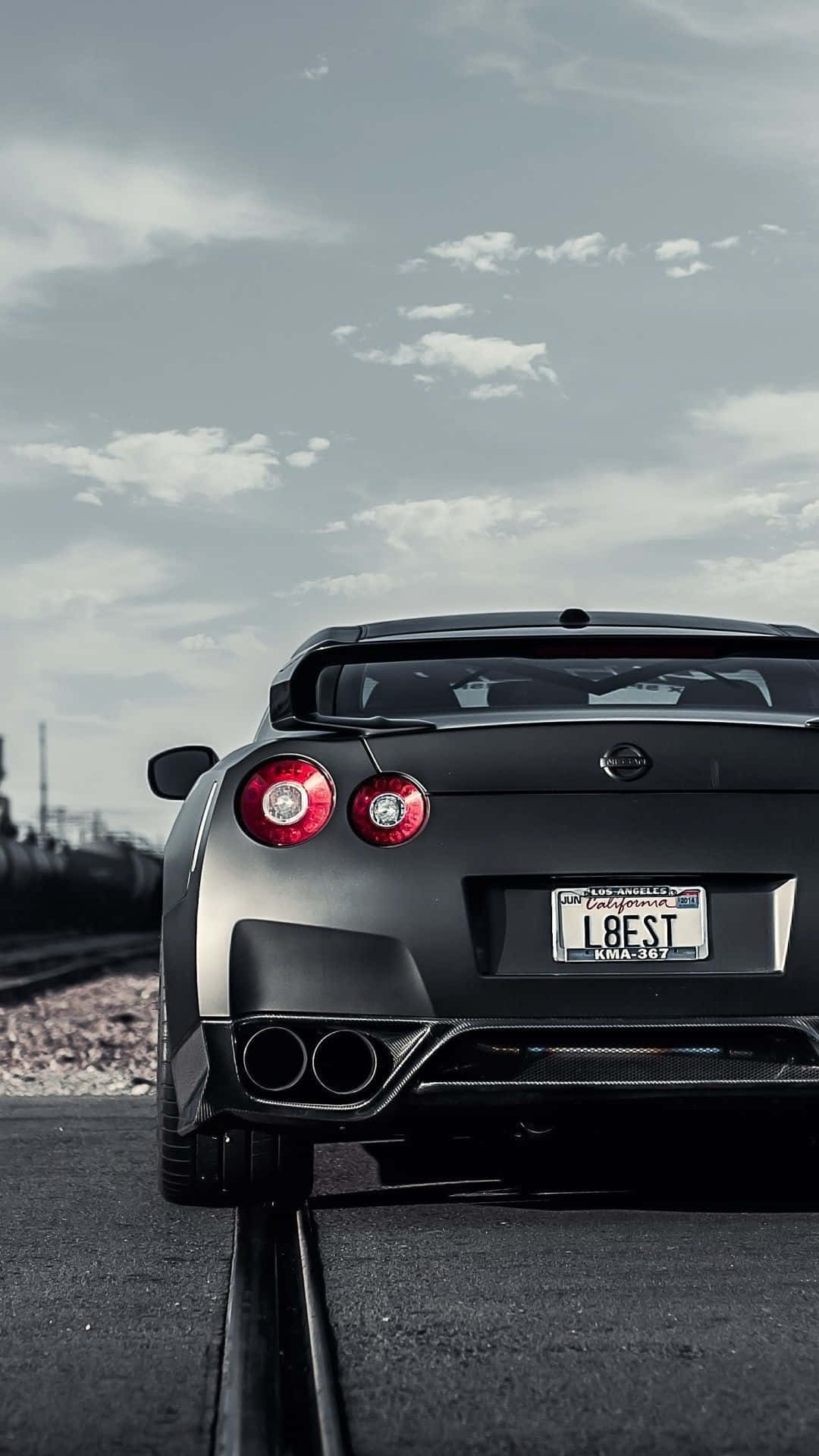 A Bright Red Nissan Gtr Sports Car Showcased Against A Blue Background. Background