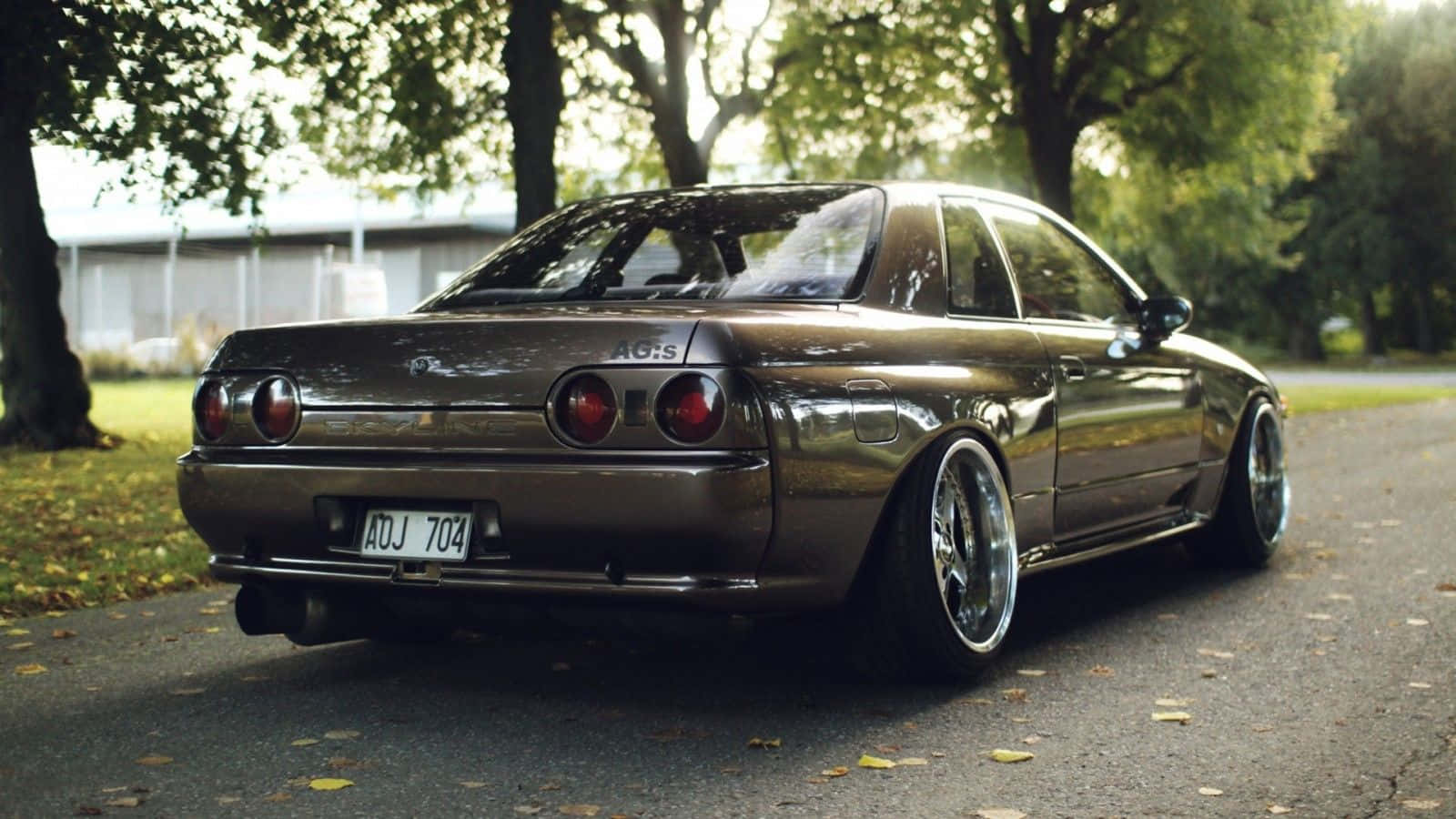 A Brown Car Parked On A Road Background