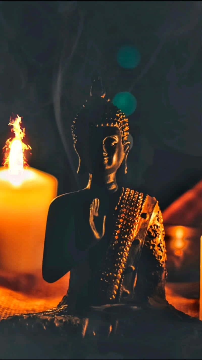 A Buddha Statue With Candles And Candles Background