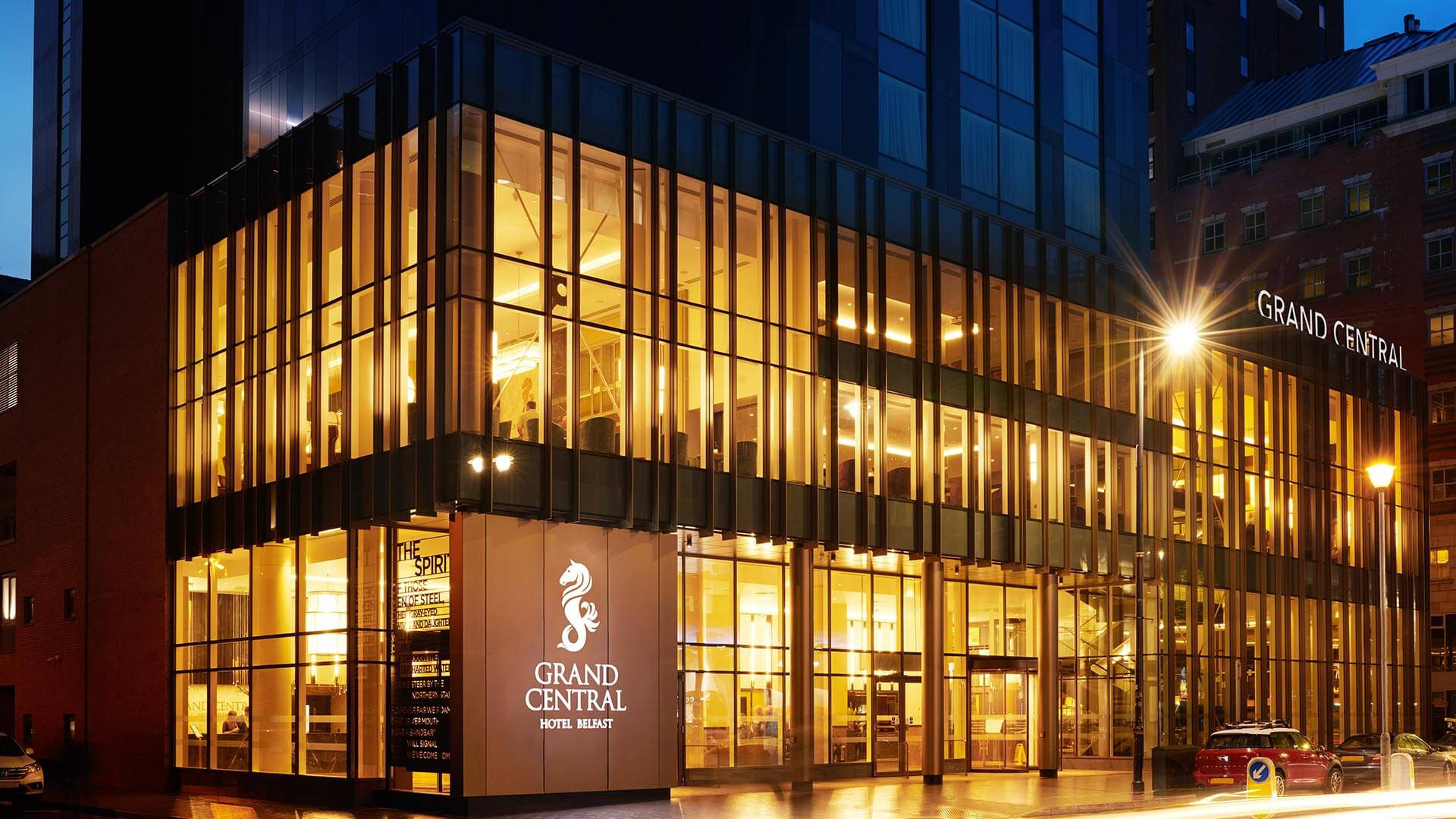 A Building With A Glass Facade At Night Background