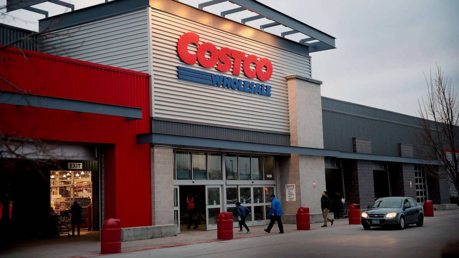 A Bustling Costco Wholesale Store With A Black Car Parked At The Front Background