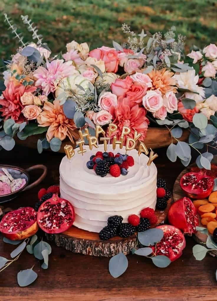 A Cake With Flowers And Fruit On Top Background