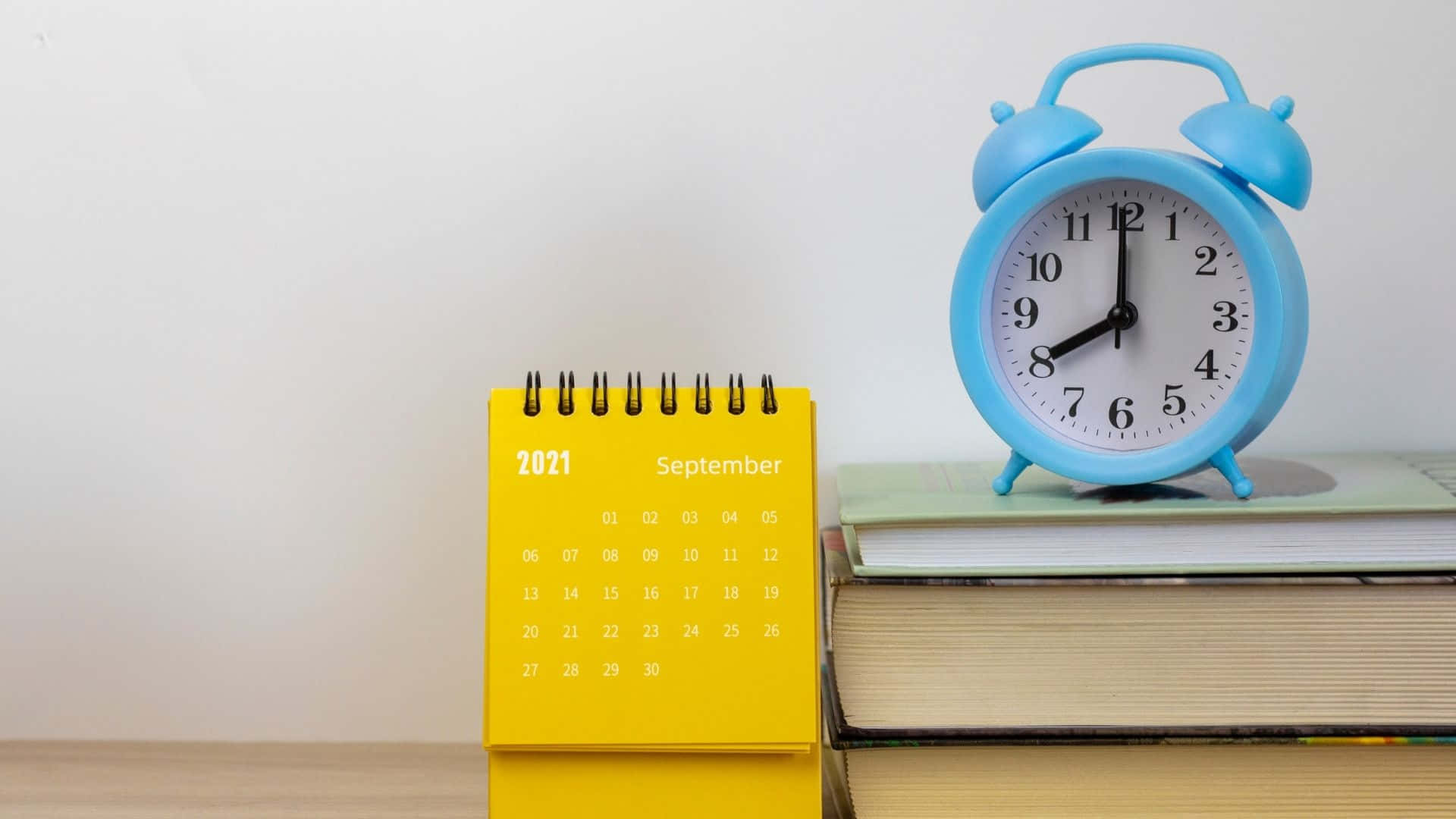 A Calendar And Books On A Table Background