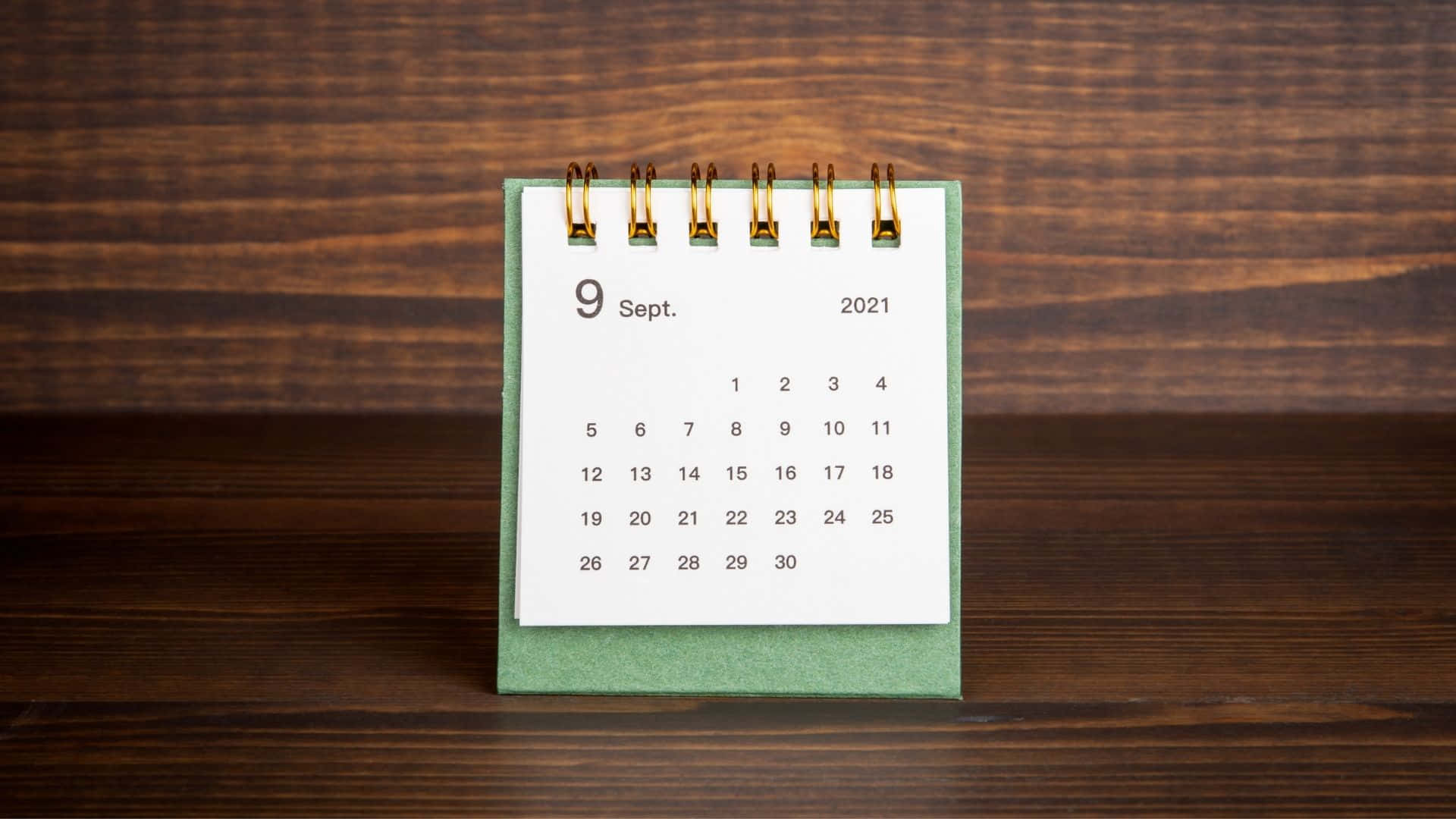 A Calendar On A Wooden Table Background