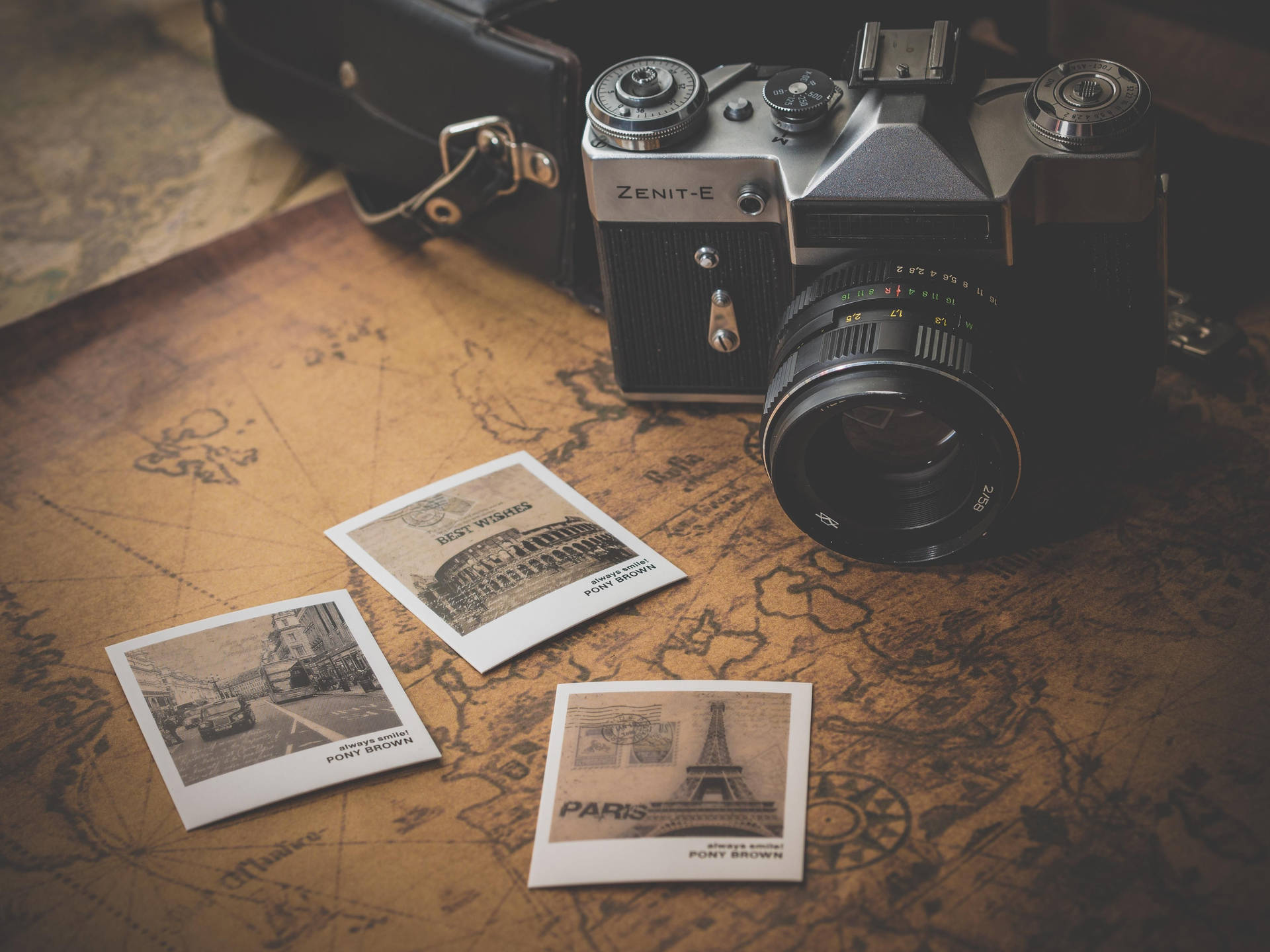 A Camera And A Map With Photos On It Background