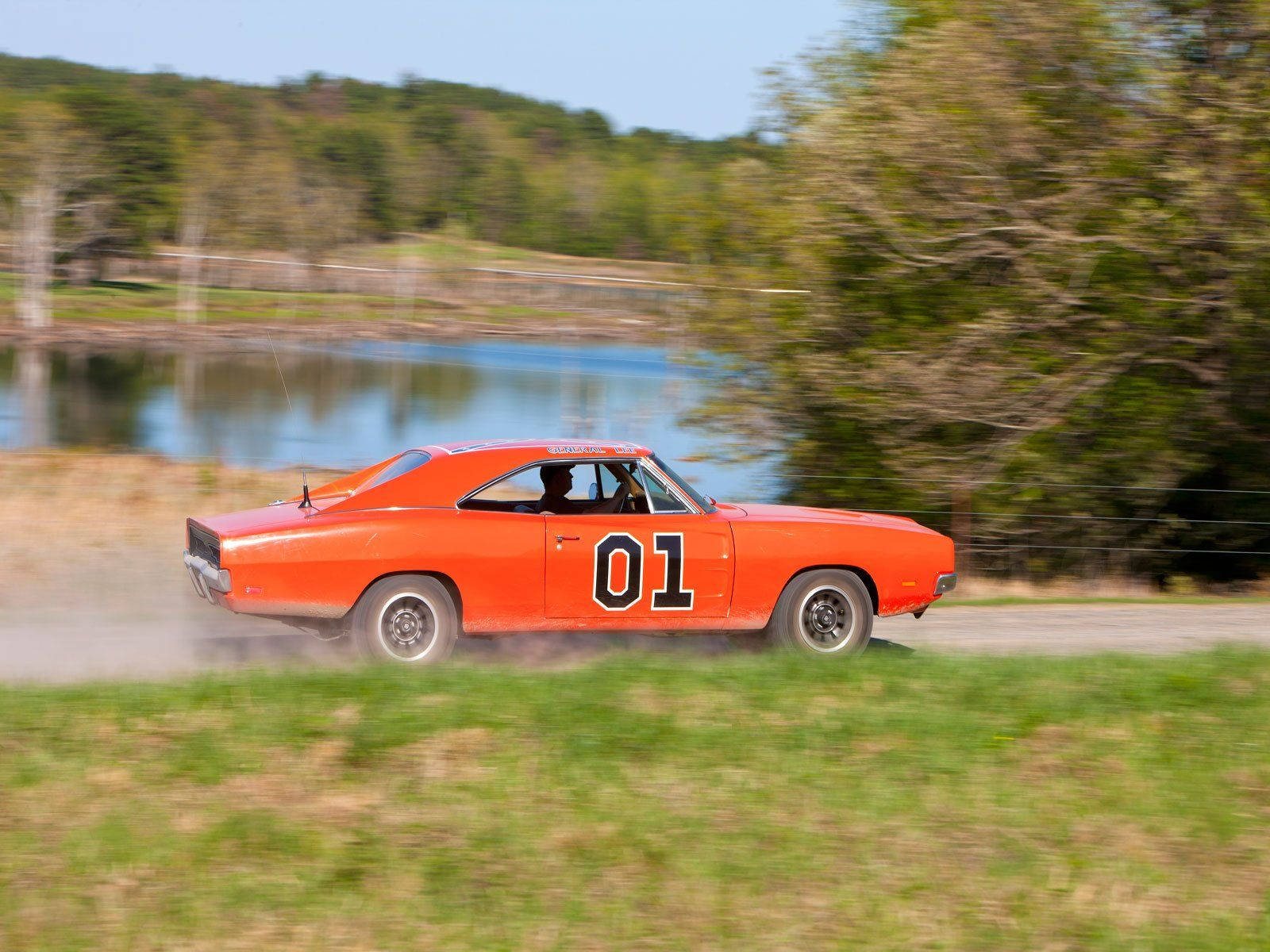 A Car Driving Down A Dirt Road Background