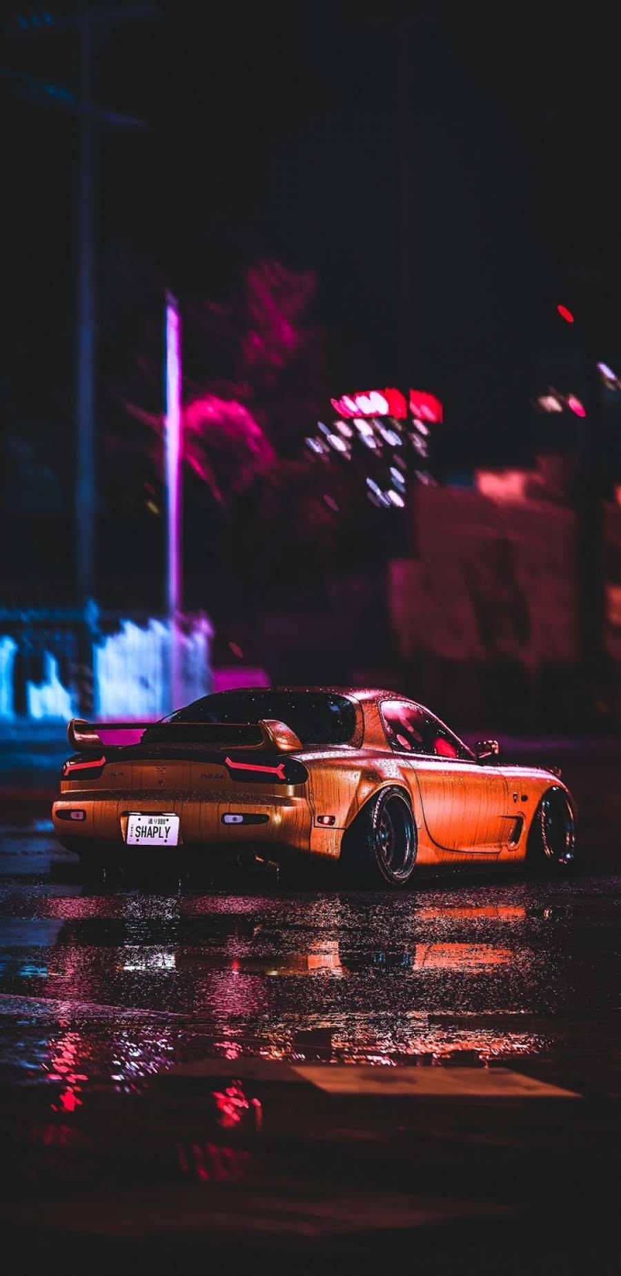 A Car Driving Down The Street At Night Background