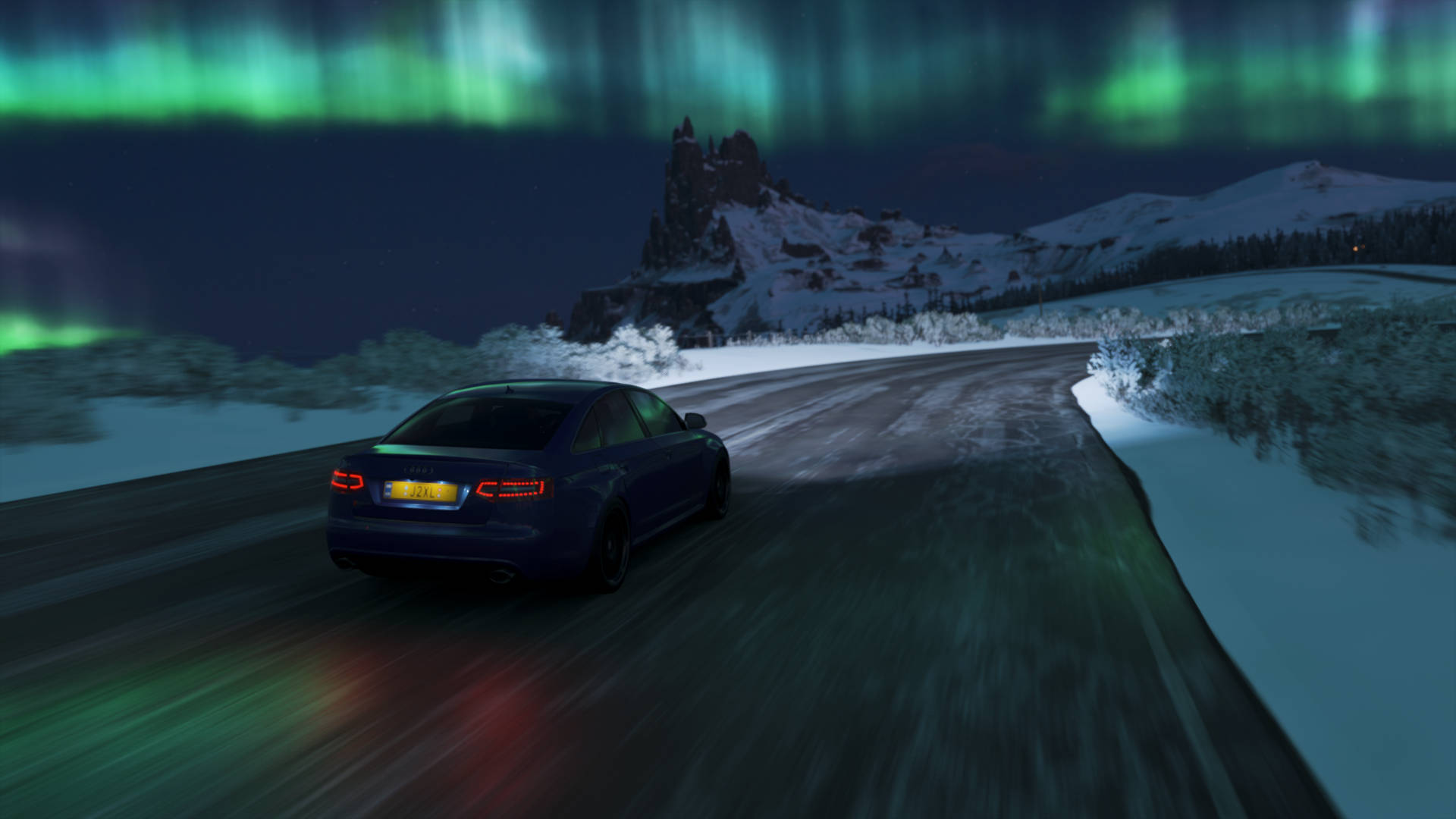 A Car Driving On A Snowy Road With The Aurora Lights On Background