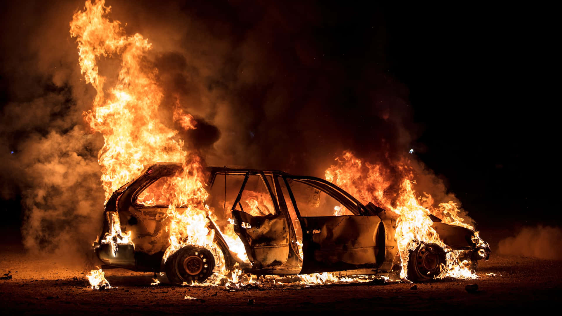 A Car Is Burning In The Desert At Night