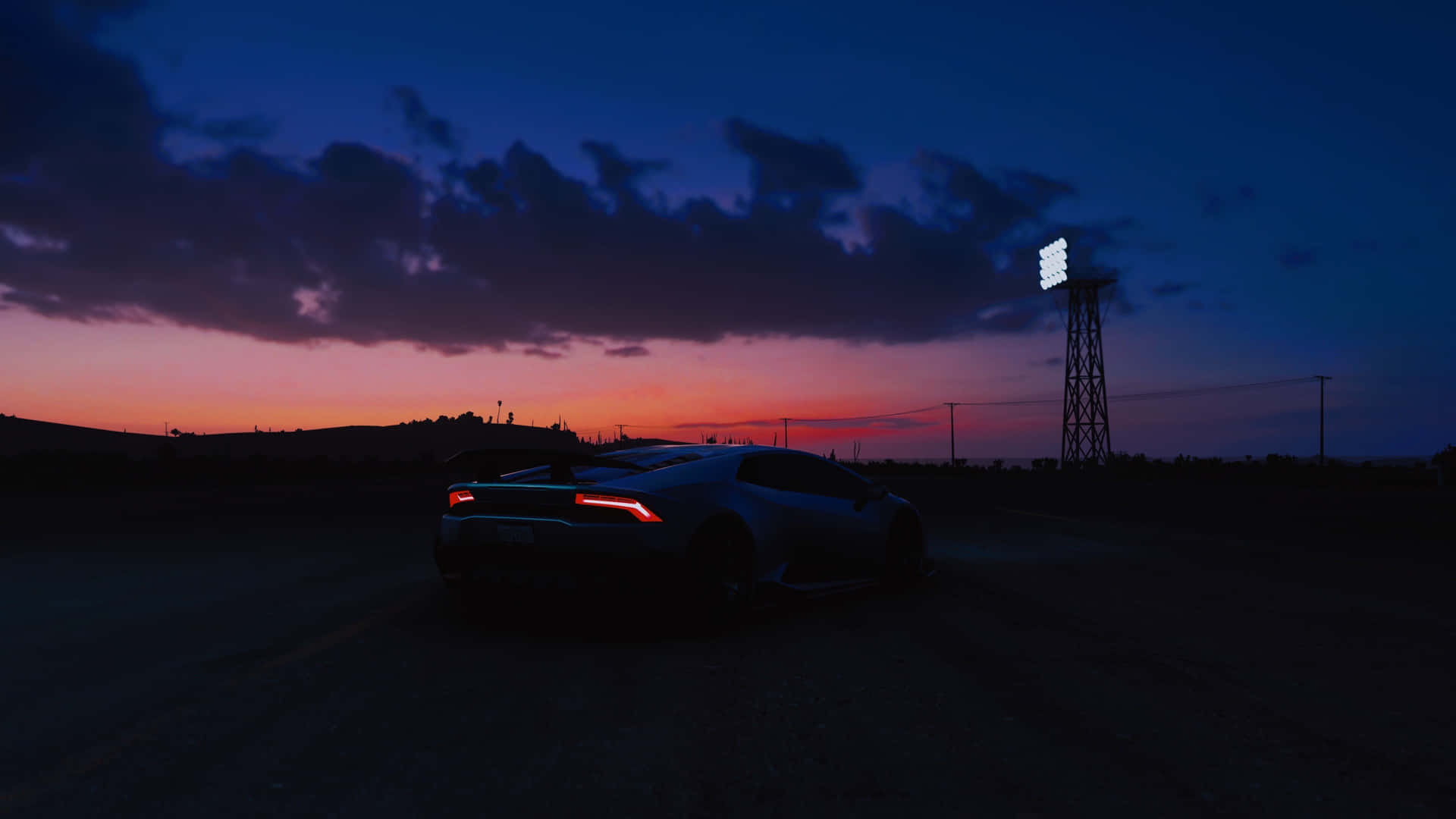 A Car Is Parked In The Middle Of A Road At Sunset Background