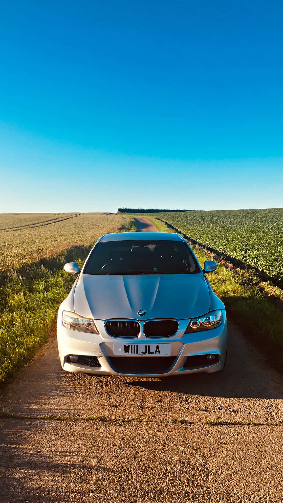 A Car Parked On A Dirt Road Background
