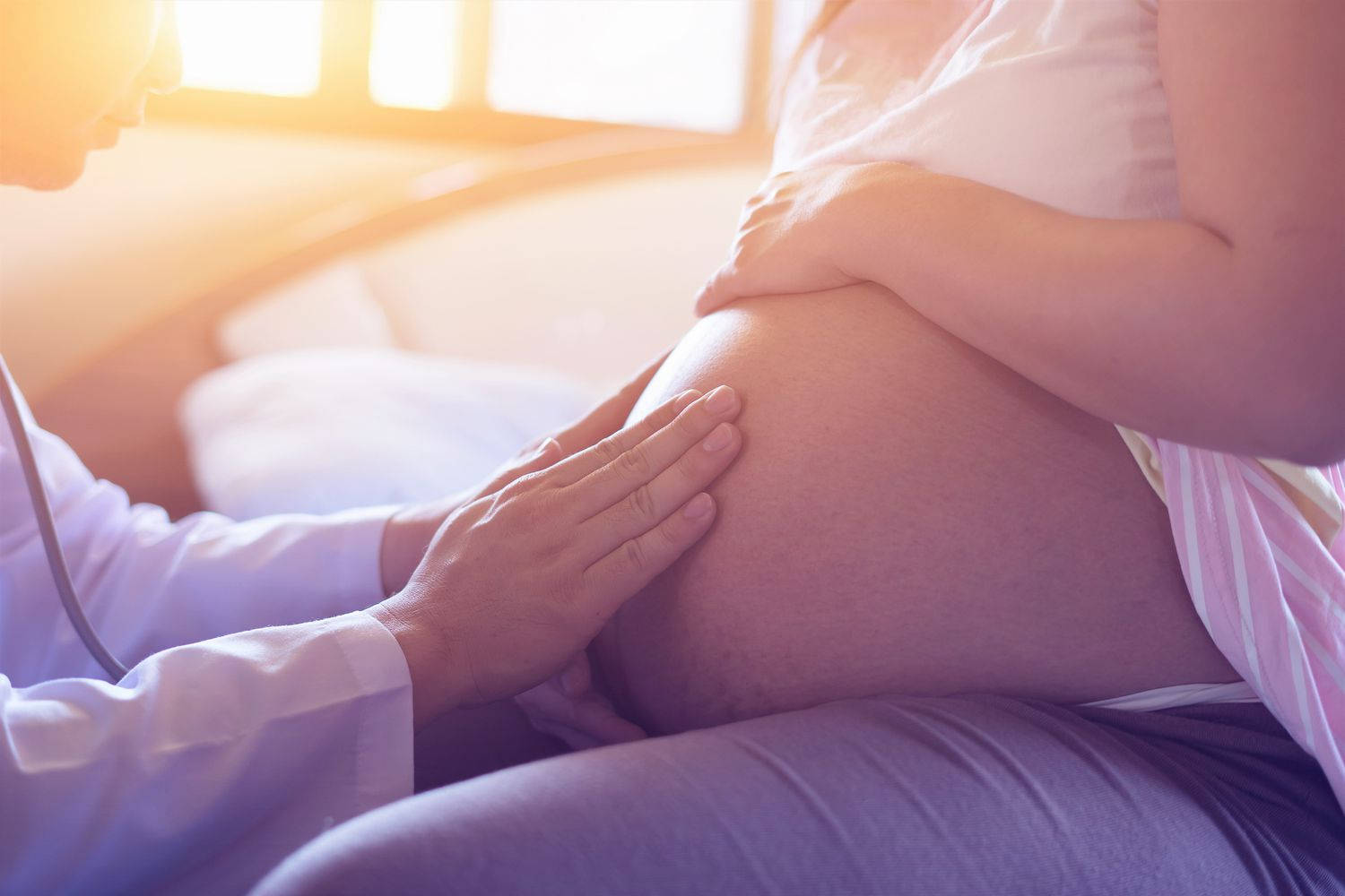 A Caring Doctor Massaging A Pregnant Belly Background