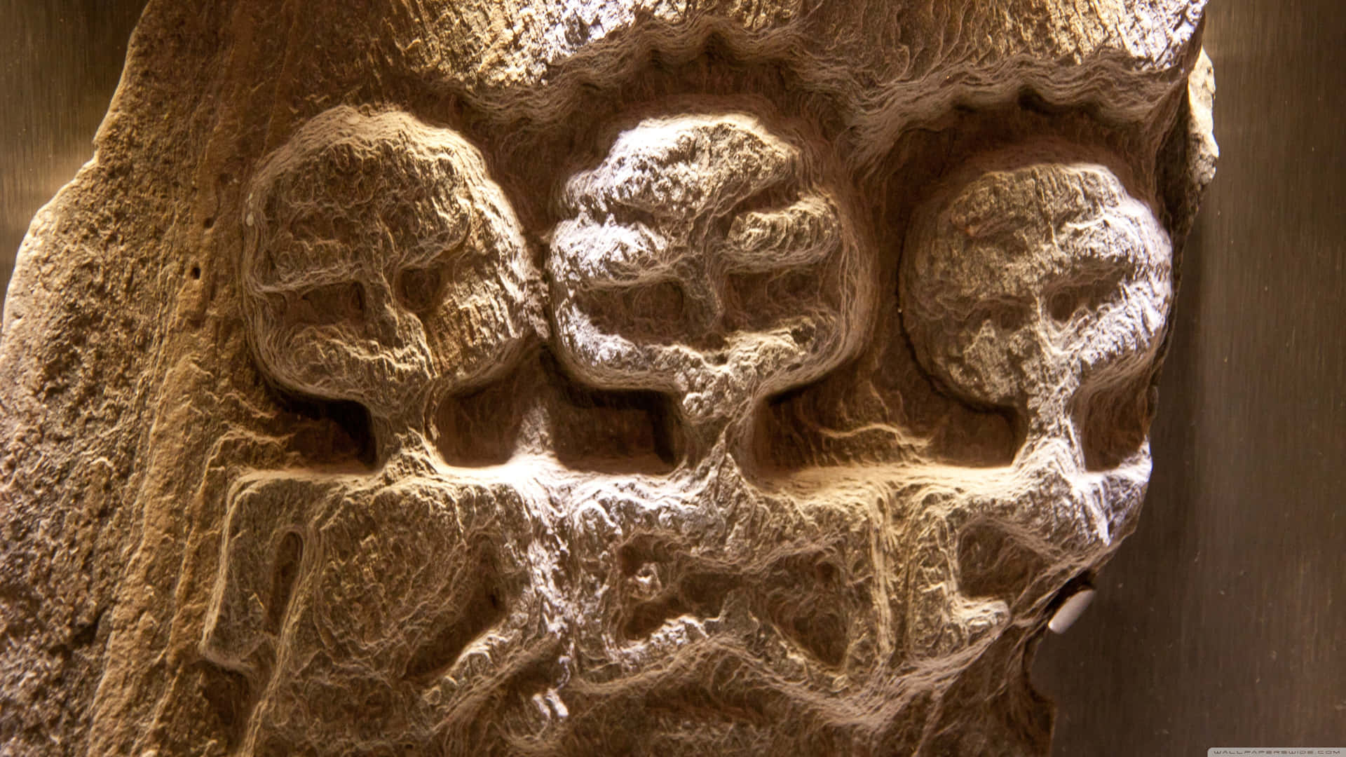 A Carving Of Three People On A Tree Background