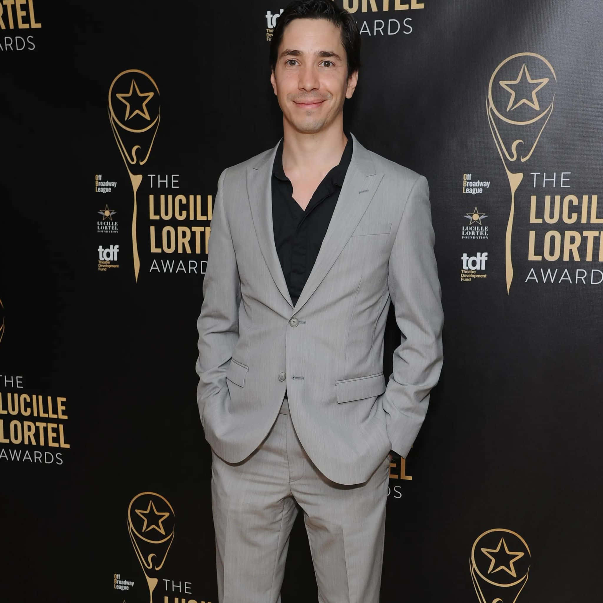 A Charismatic Justin Long Posing For A Captivating Portrait Background