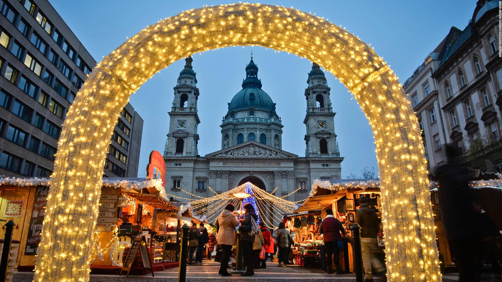 A Christmas Market With Lights In Front Of A Church Background