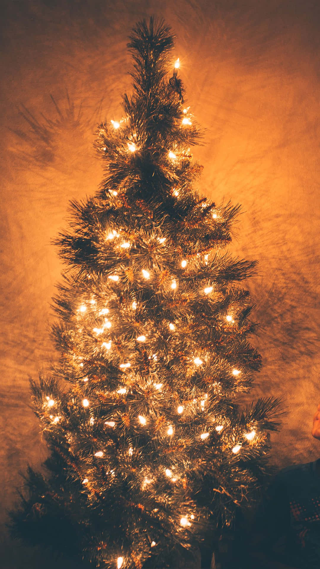 A Christmas Tree With Lights In The Background