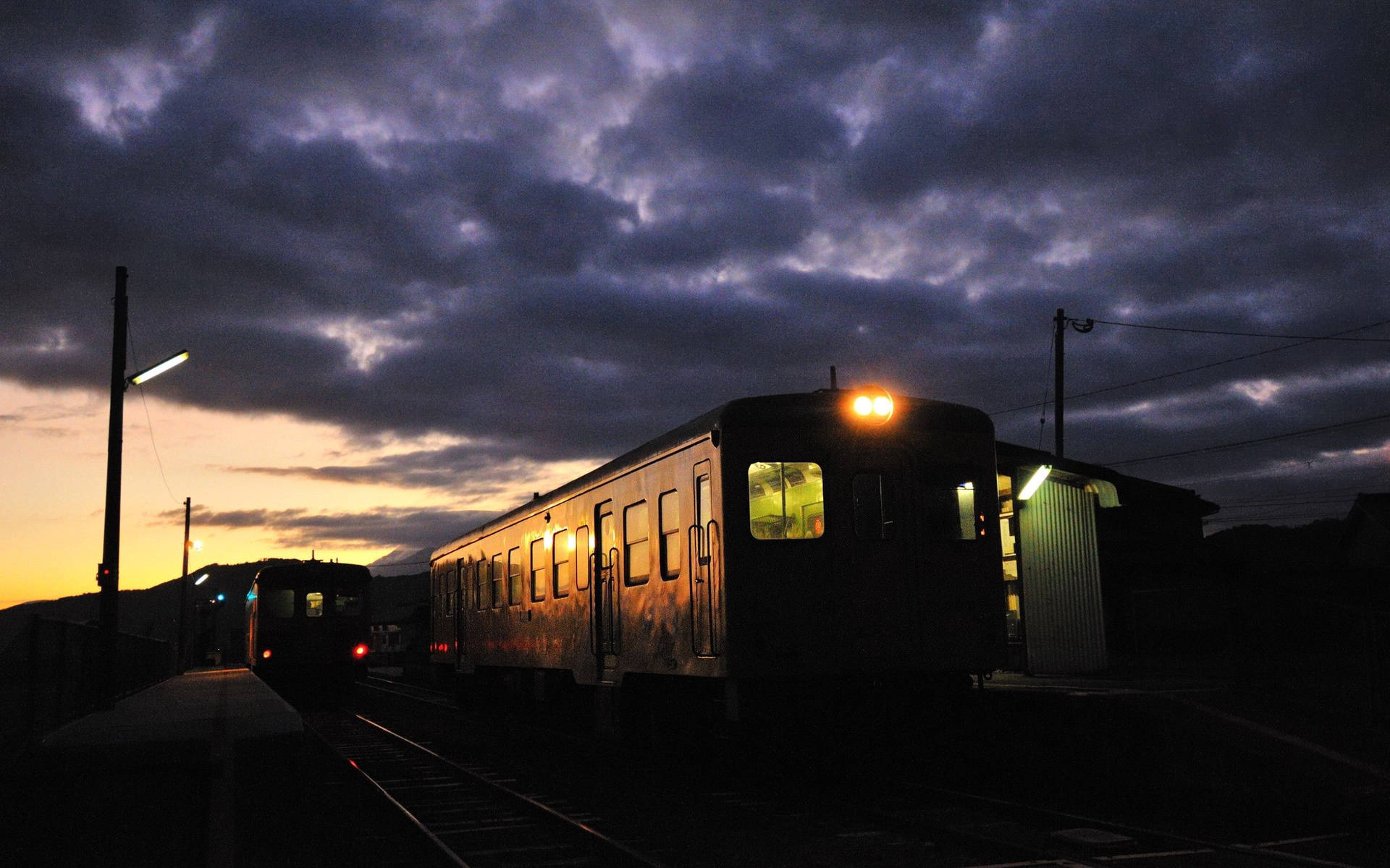 A Chugging Train Heads Into The Orange Sunset