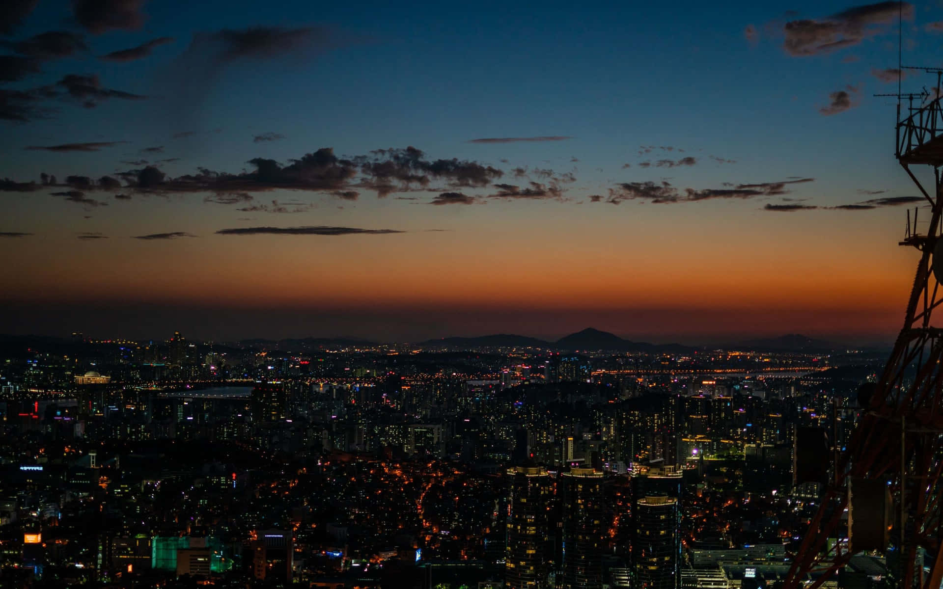 A City At Dusk With A Tower Background
