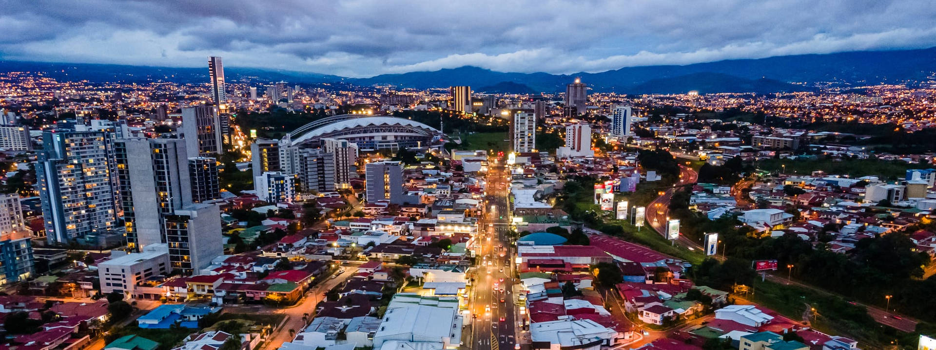 A City At Night With A Mountain In The Background