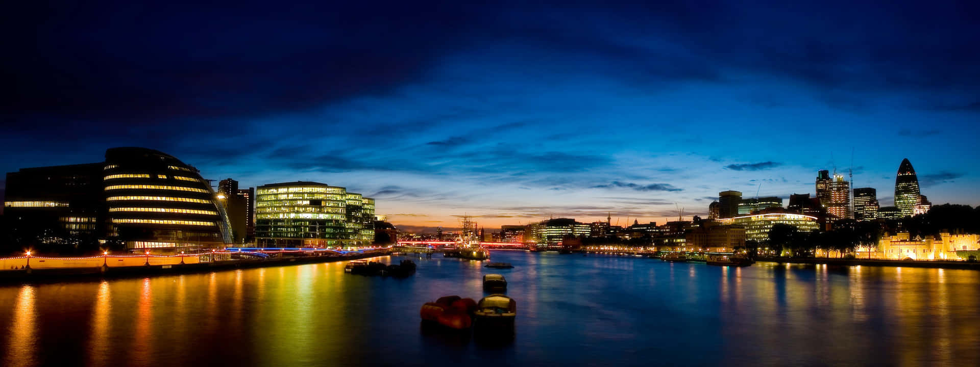A City At Night With A River And Buildings Background
