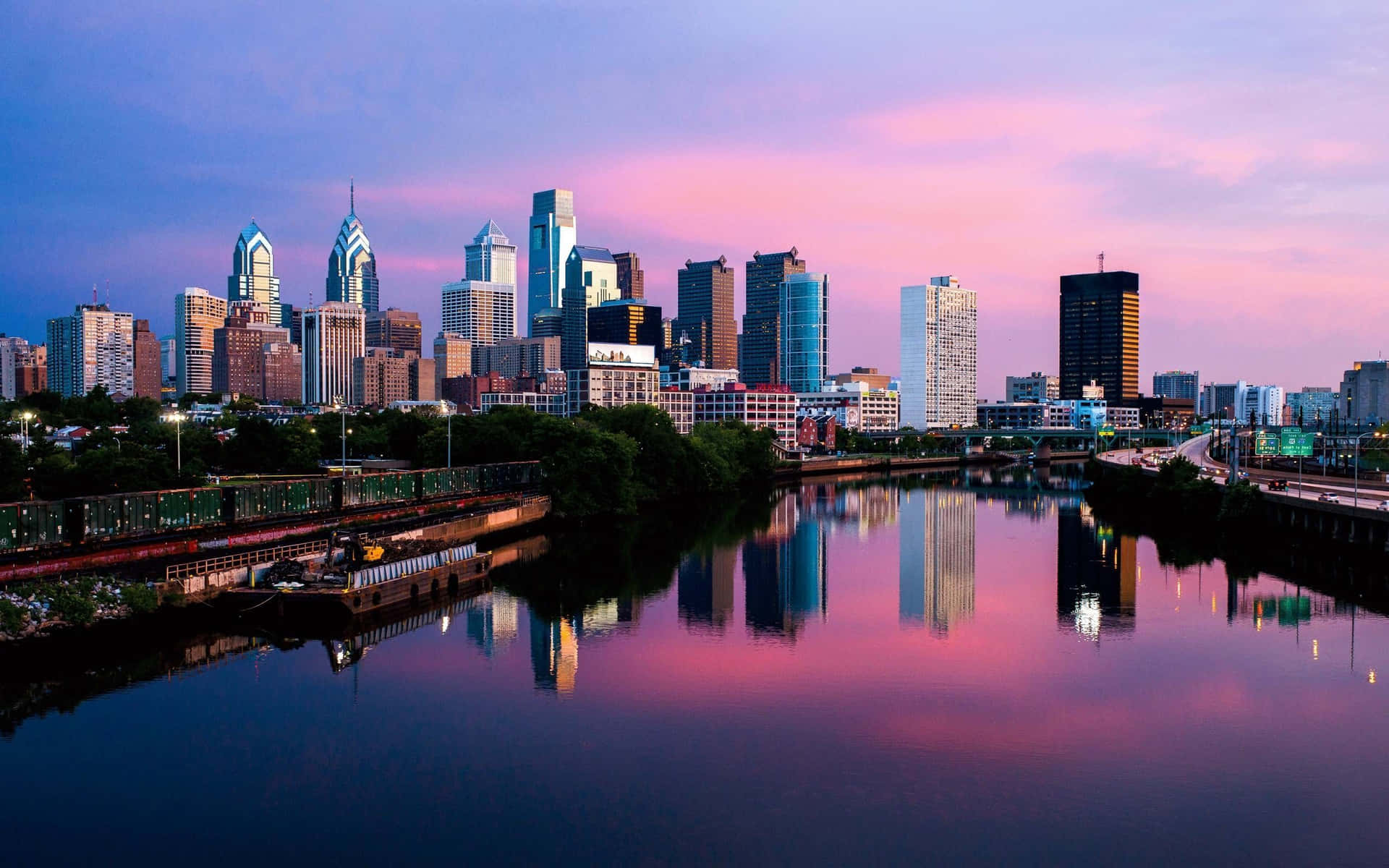 A City Skyline With A River In The Background Background