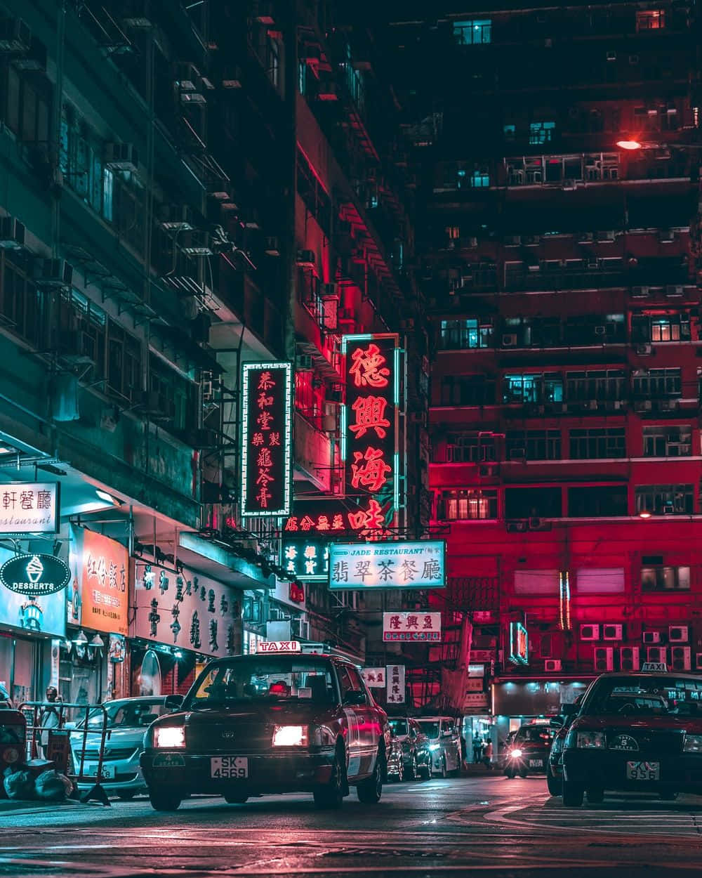 A City Street At Night With Neon Signs Background