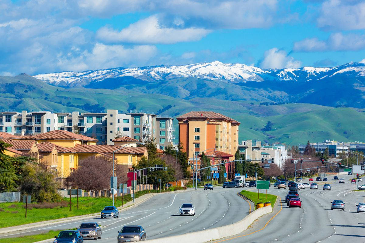 A City Street With A Mountain In The Background Background