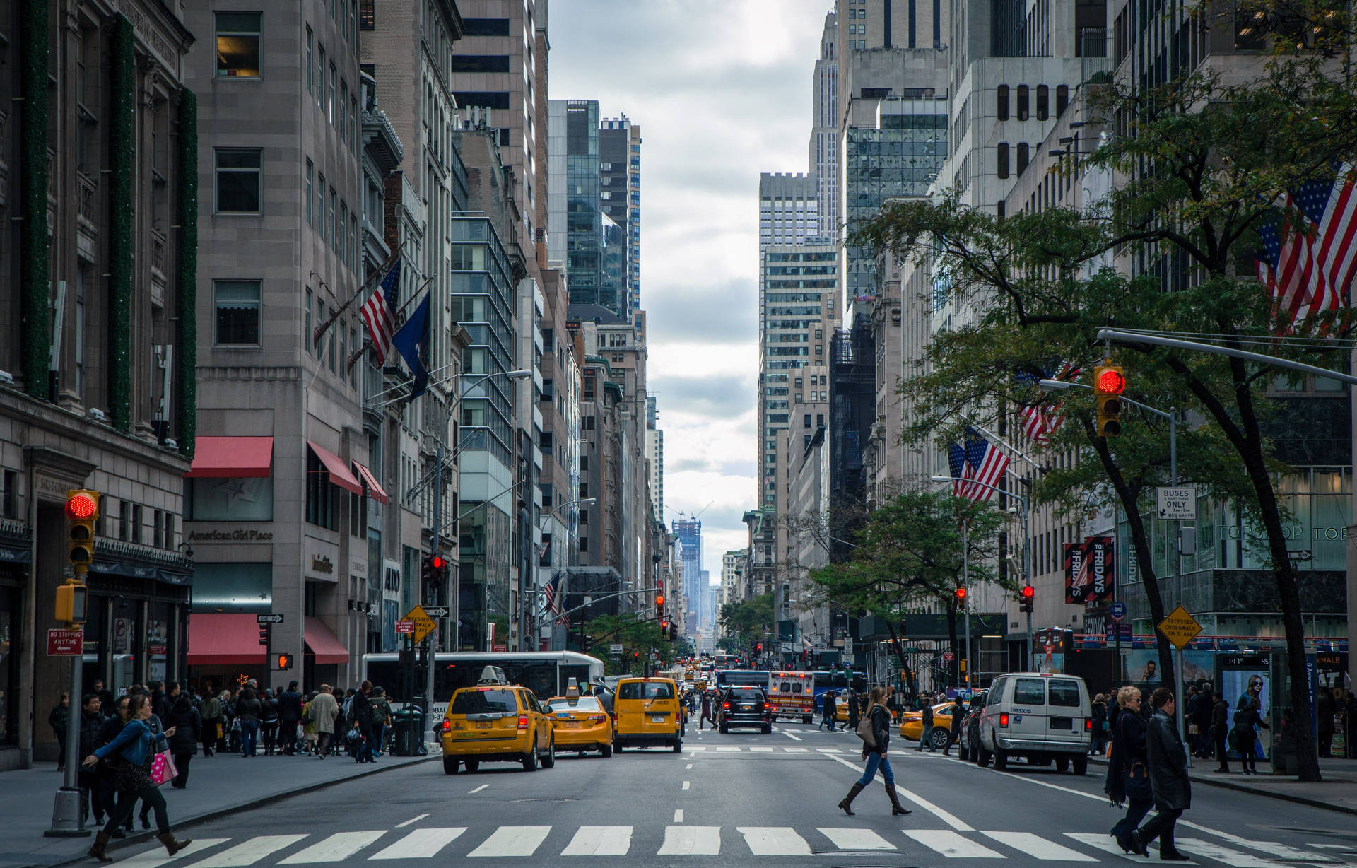 A City Street With Many People Walking And Crossing Background