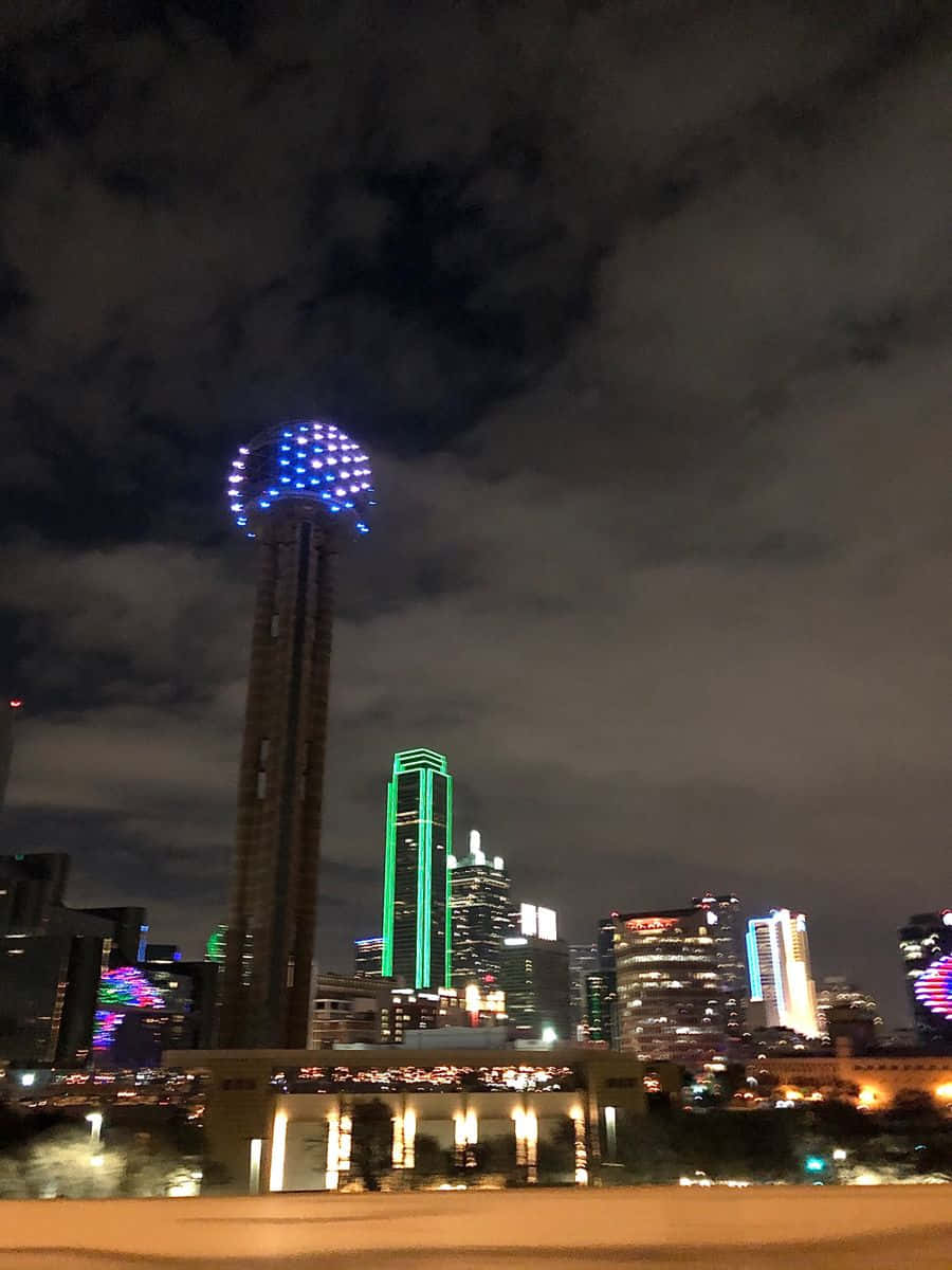 A City With A Blue And Green Light Tower