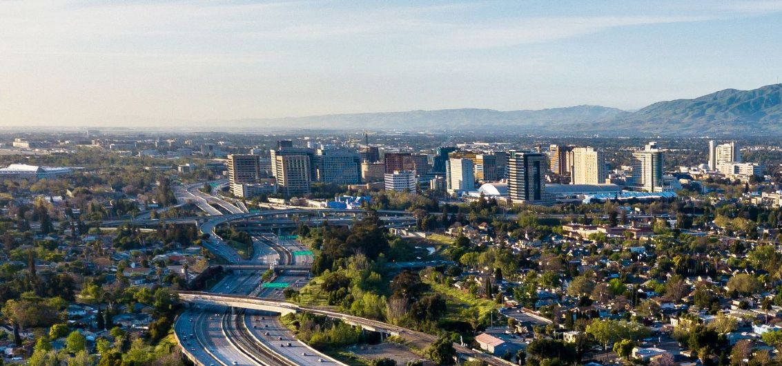 A City With A Highway And Trees In The Background Background