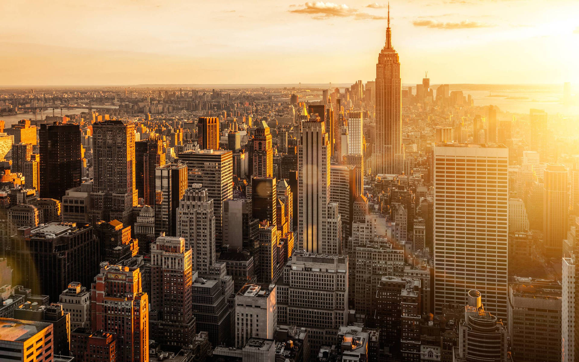 A Cityscape With Buildings And A Sun Setting Background