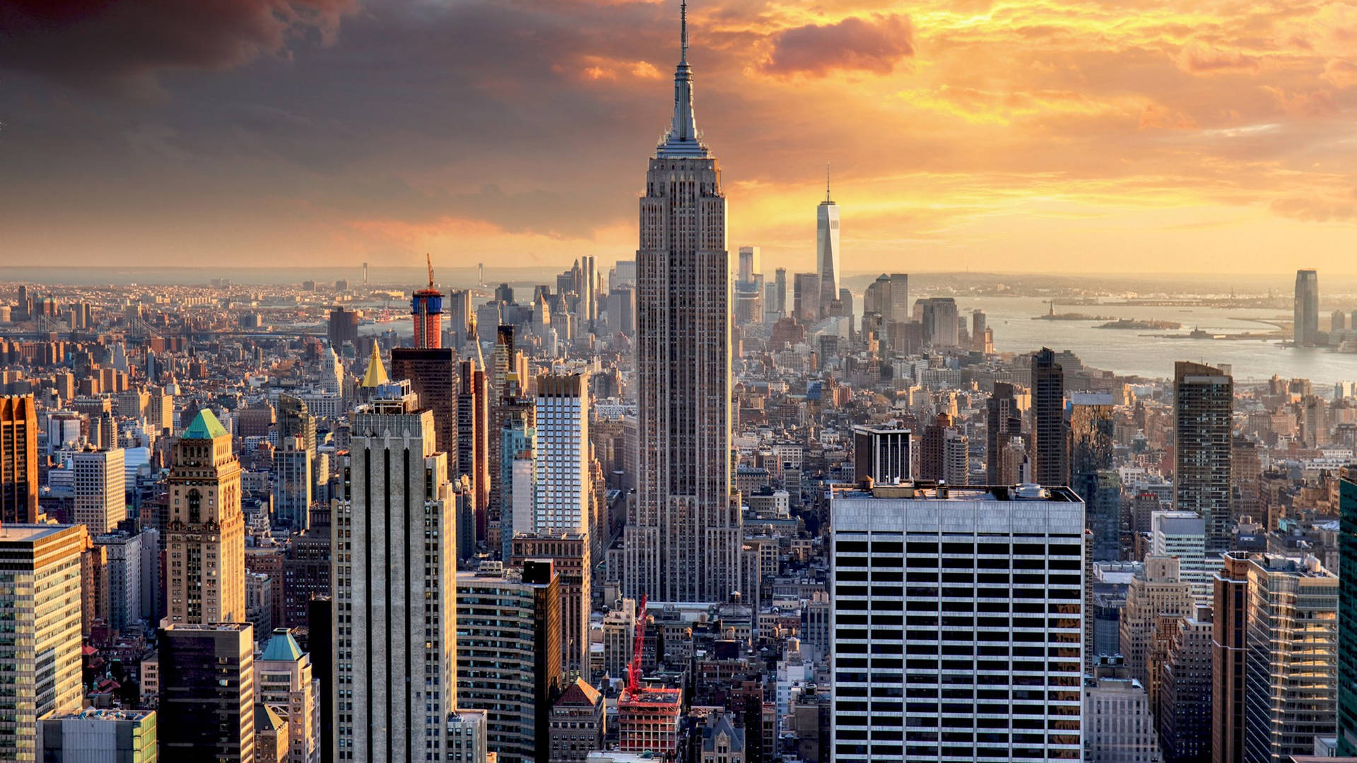 A Cityscape With Buildings And A Sunset Background